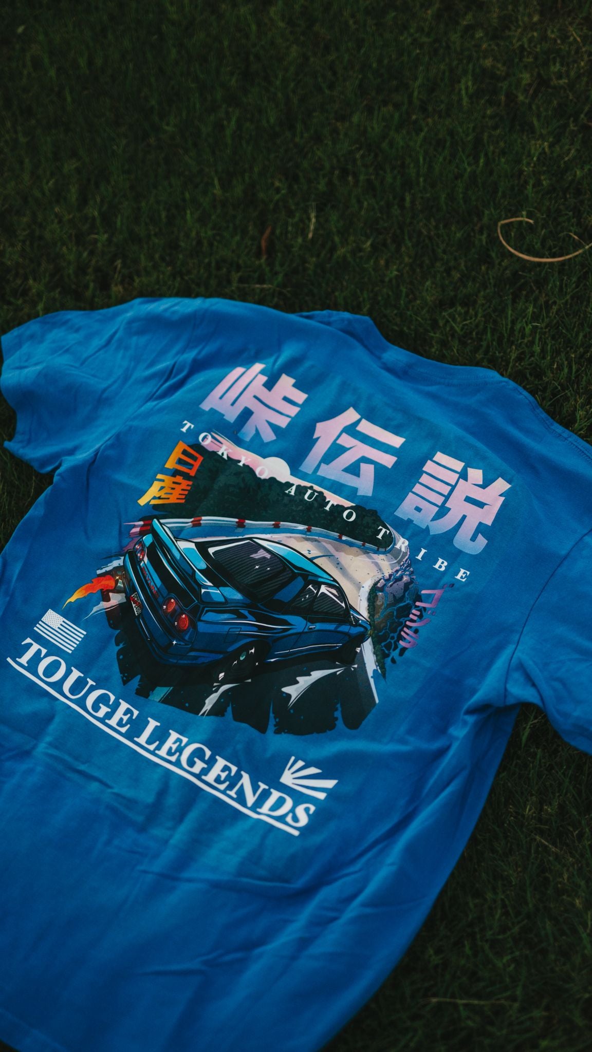 Blue "Touge Legends (more colors)" graphic tee featuring a drifting Japanese car on a mountain road with stylized Japanese text and automotive streetwear design inspired by tuner culture.
