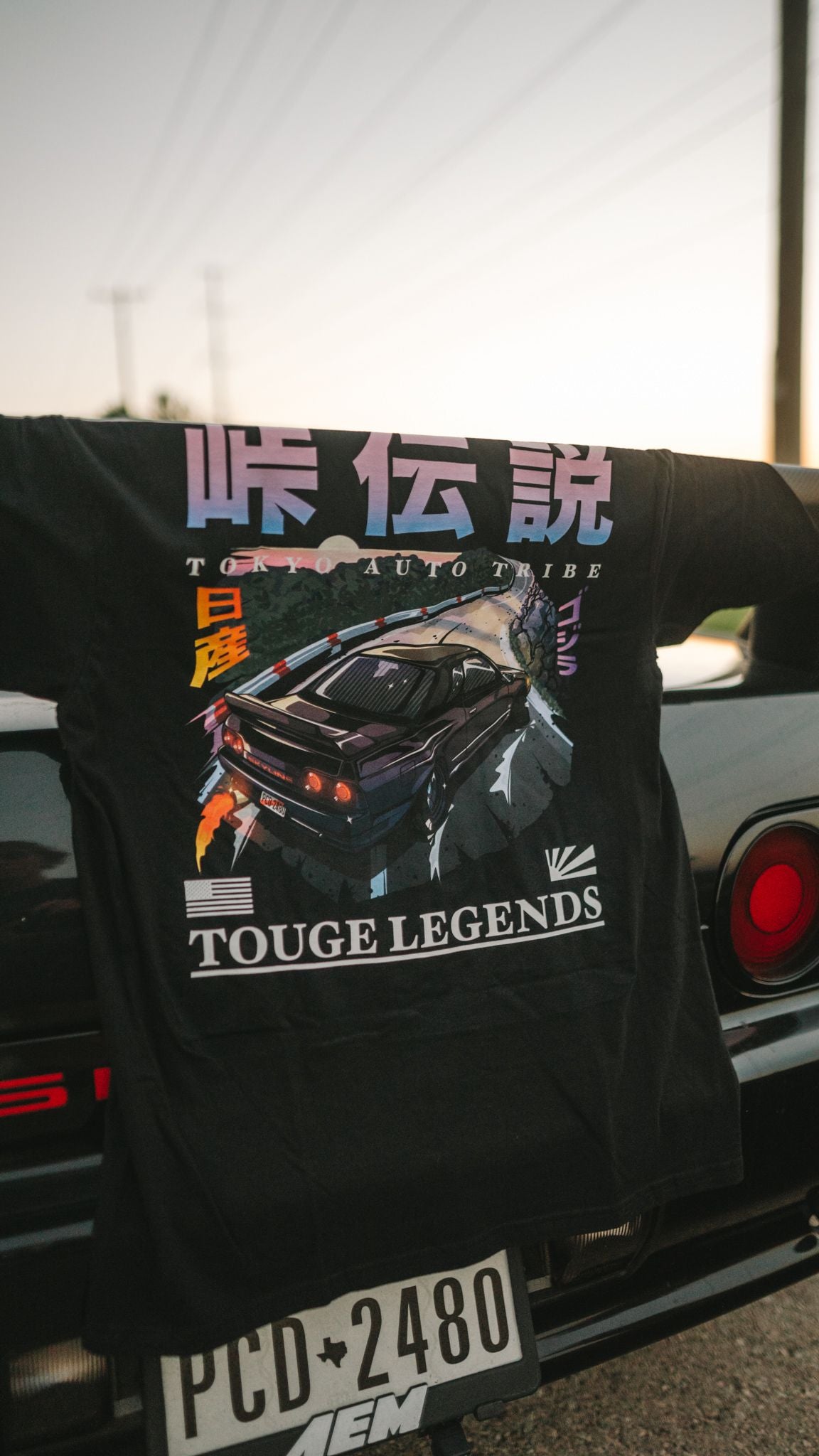 Black graphic tee with colorful "Touge Legends (more colors)" design showing a drift car drifting on a mountain pass, capturing Japanese car culture and late-night drives vibe.