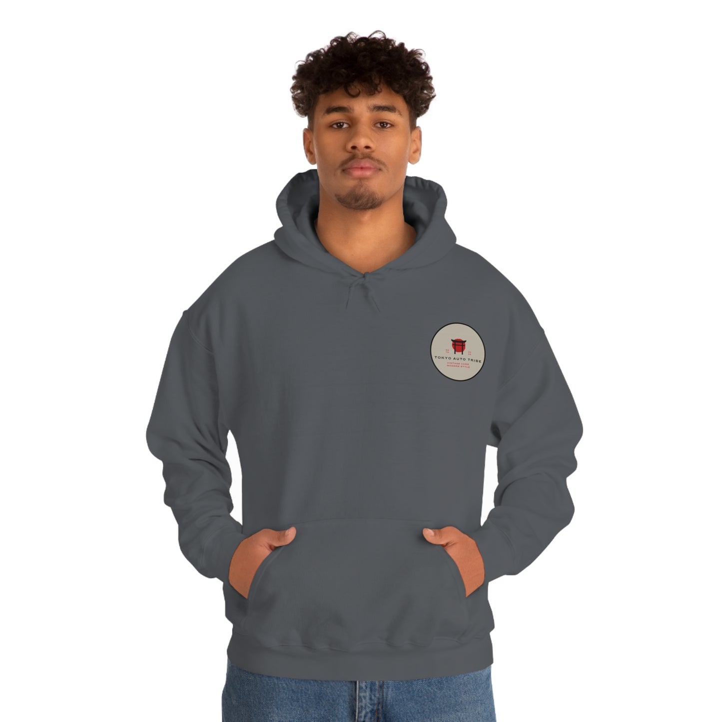 Man wearing a dark gray Wagon Chibi Hoodie featuring a small circular logo on the chest, embodying the spirit of Japanese car culture and late-night drives.