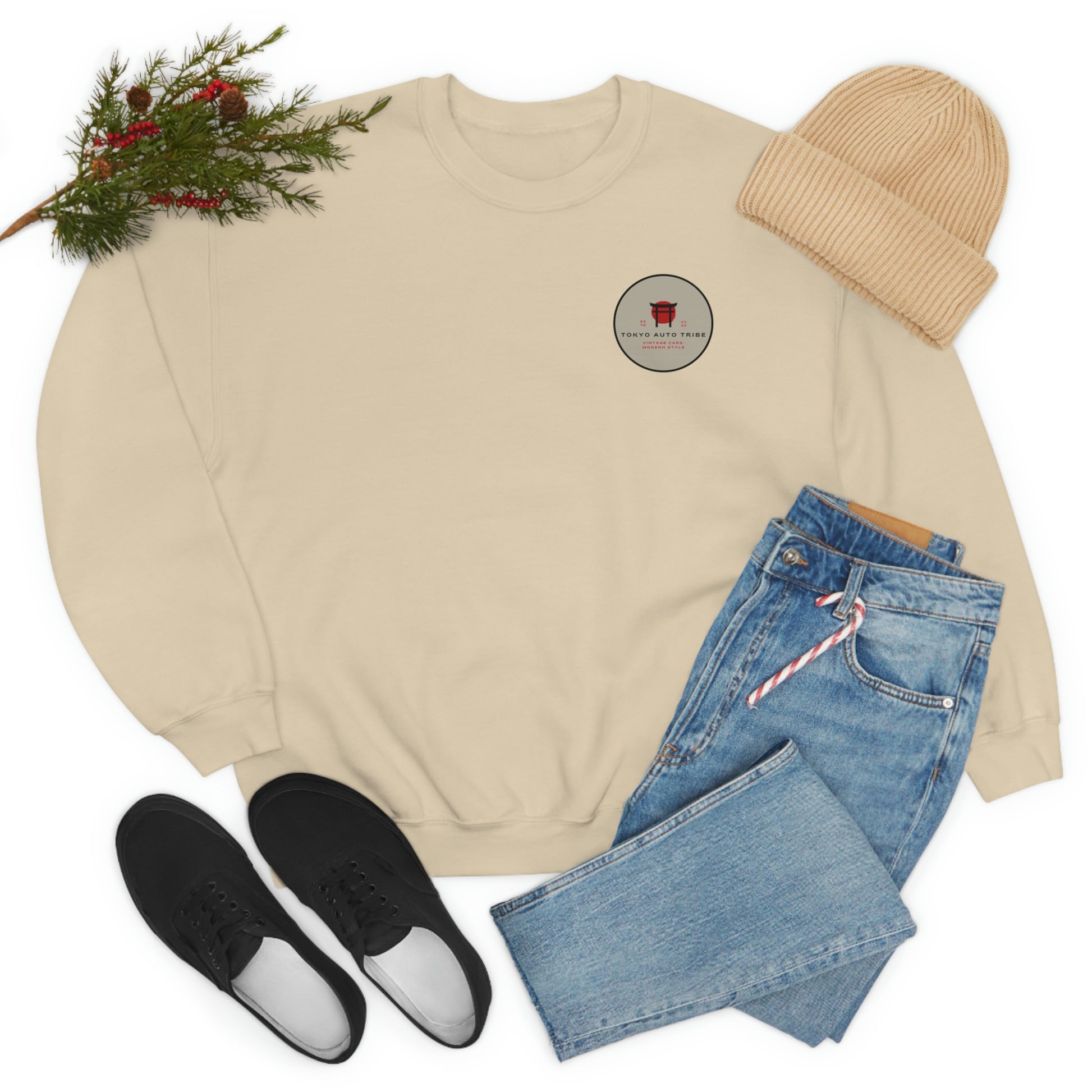 The Family Wagon Sweater in beige with a small red and black graphic on chest, styled with blue jeans, black shoes, and a beige knit hat, inspired by Japanese car culture and late-night drives.