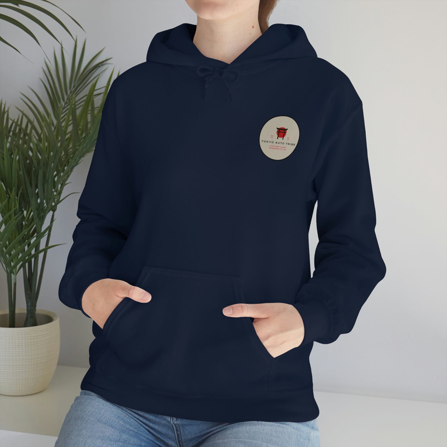 Person wearing a navy blue Groovy Grocery Runner Hoodie with a small circular logo on the chest, hands in front pocket, styled for Japanese car culture enthusiasts.