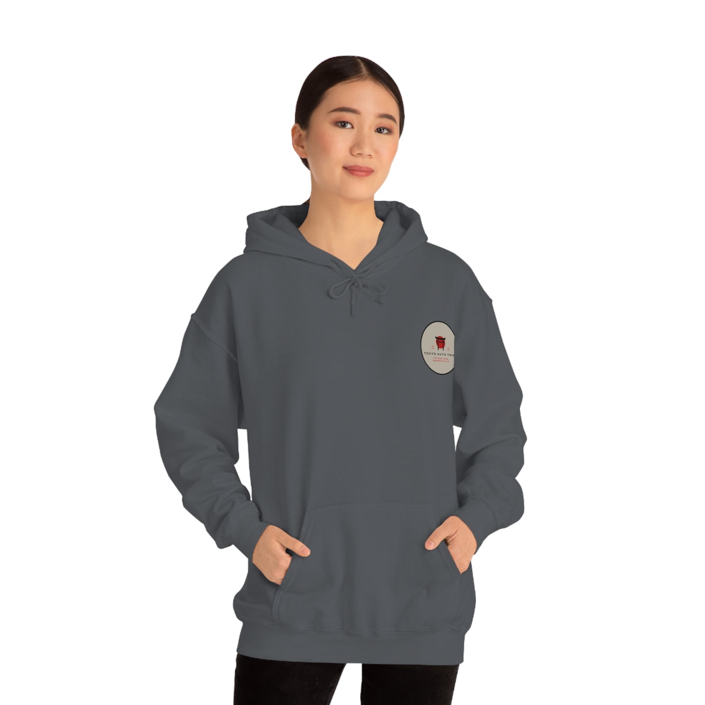 Woman wearing a dark gray Wagon Chibi Hoodie featuring a small graphic on the chest, designed for fans of Japanese car culture and late-night drives.