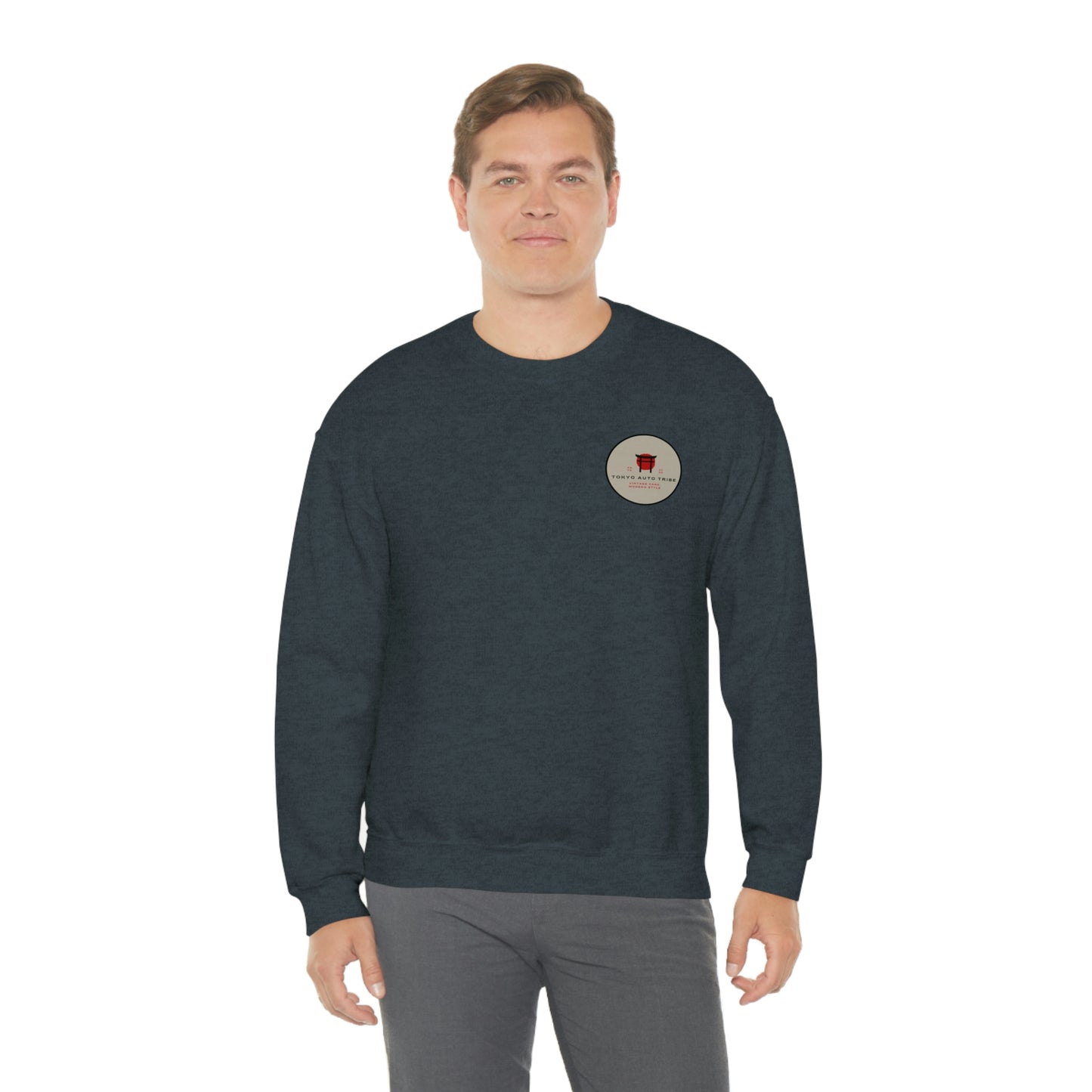 A man wearing The Family Wagon Sweater in dark gray with a small circular Tokyo Auto Tribe graphic on the chest, embodying JDM-inspired car culture streetwear.