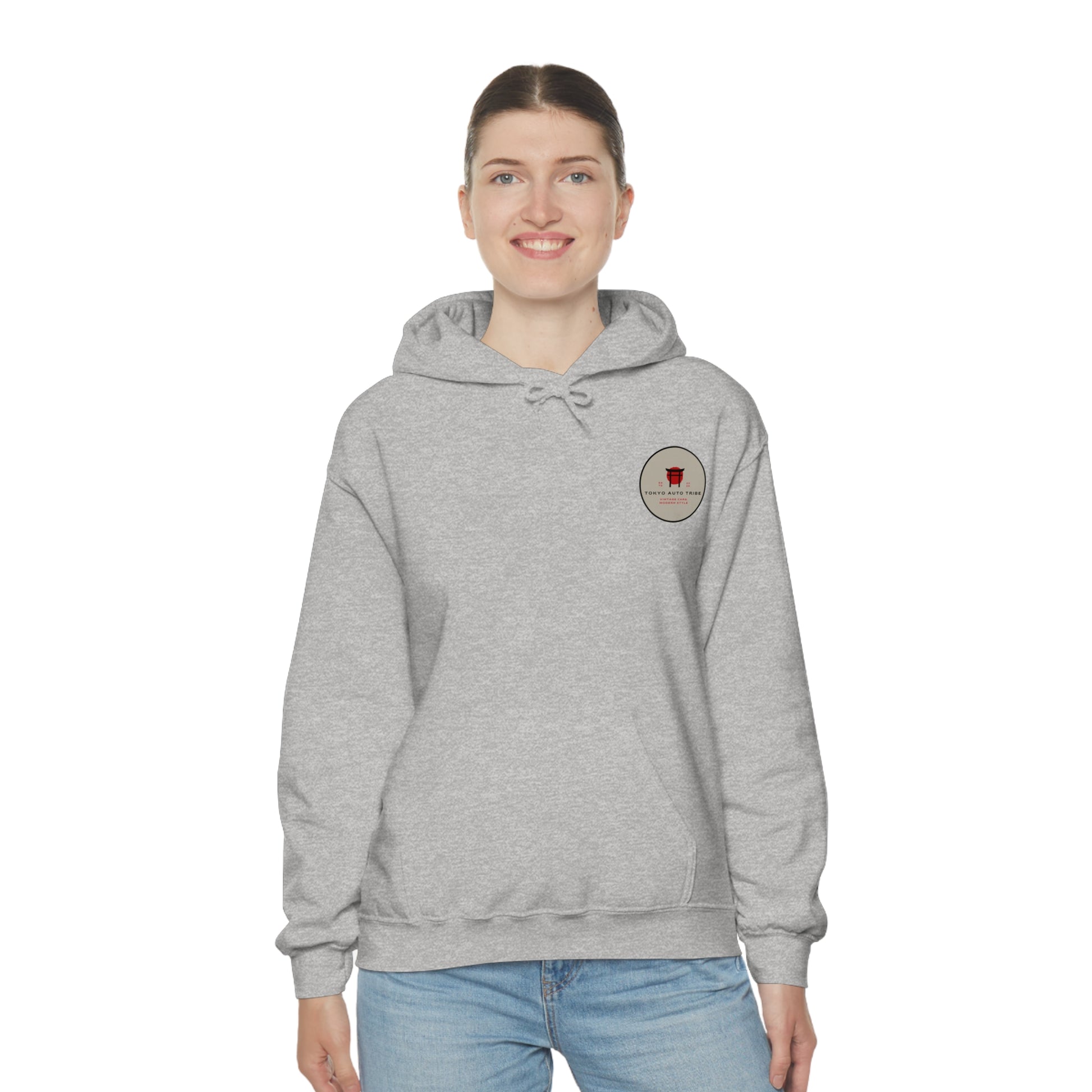 Woman wearing a light gray Wagon Chibi Hoodie featuring a small round Japanese car culture graphic on the chest, styled for fans of late-night drives and tuner car culture.