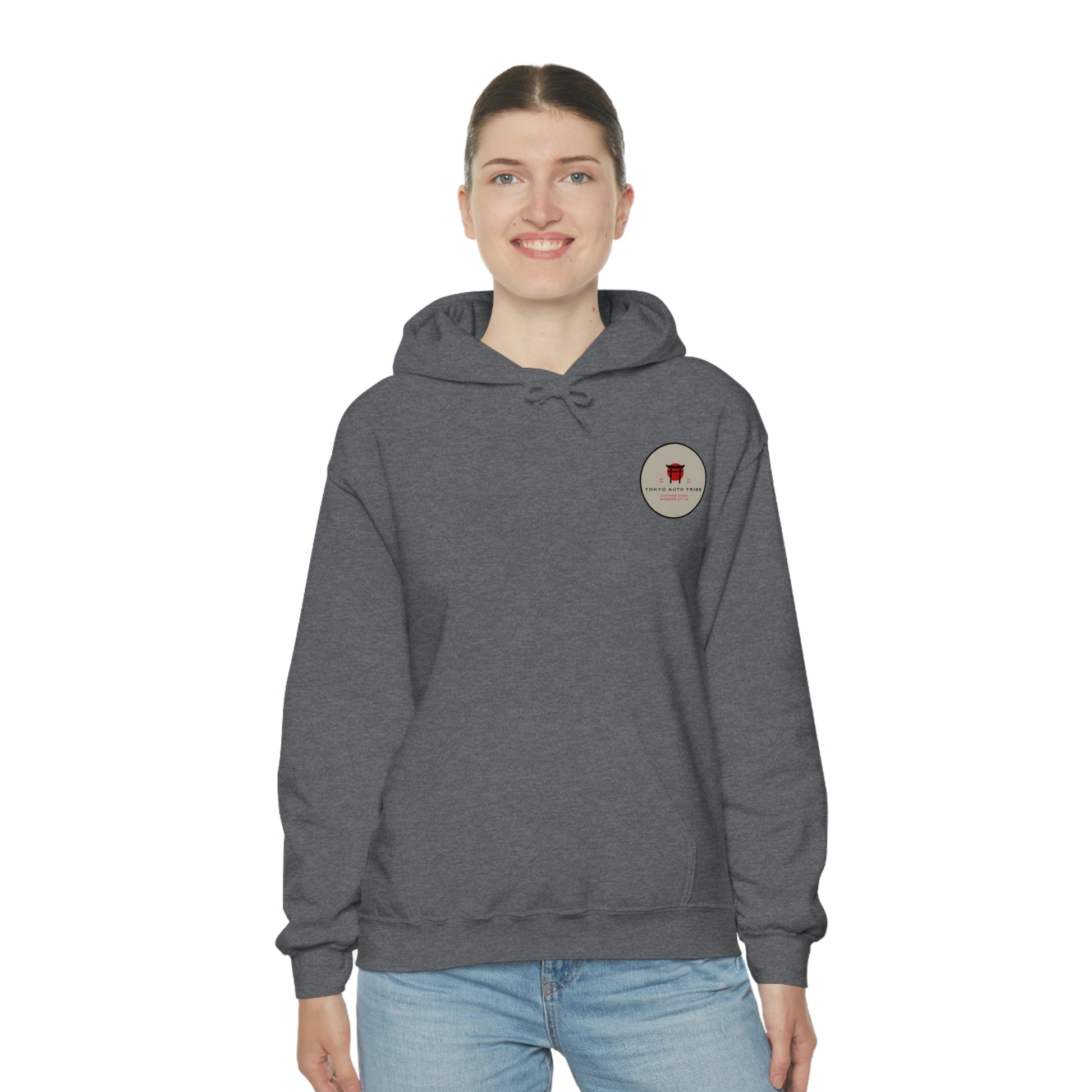 Woman wearing a dark gray Groovy Grocery Runner Hoodie featuring a small vintage-style logo on the chest, embodying Japanese car culture and late-night drive streetwear.