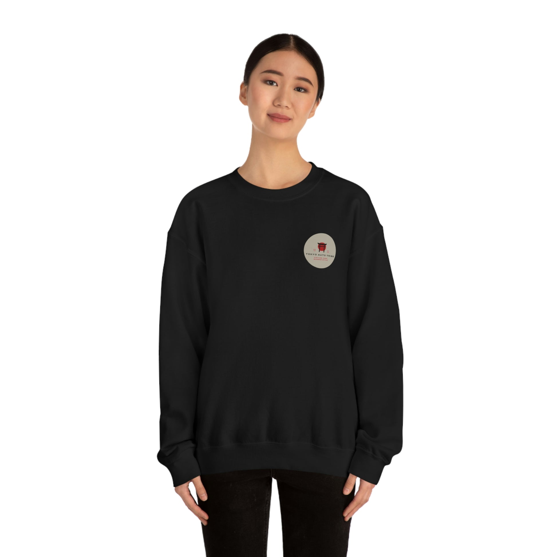 Woman wearing a black sweatshirt featuring a small circular patch on the chest, styled as The Family Wagon Sweater with minimalist Japanese car culture inspiration.