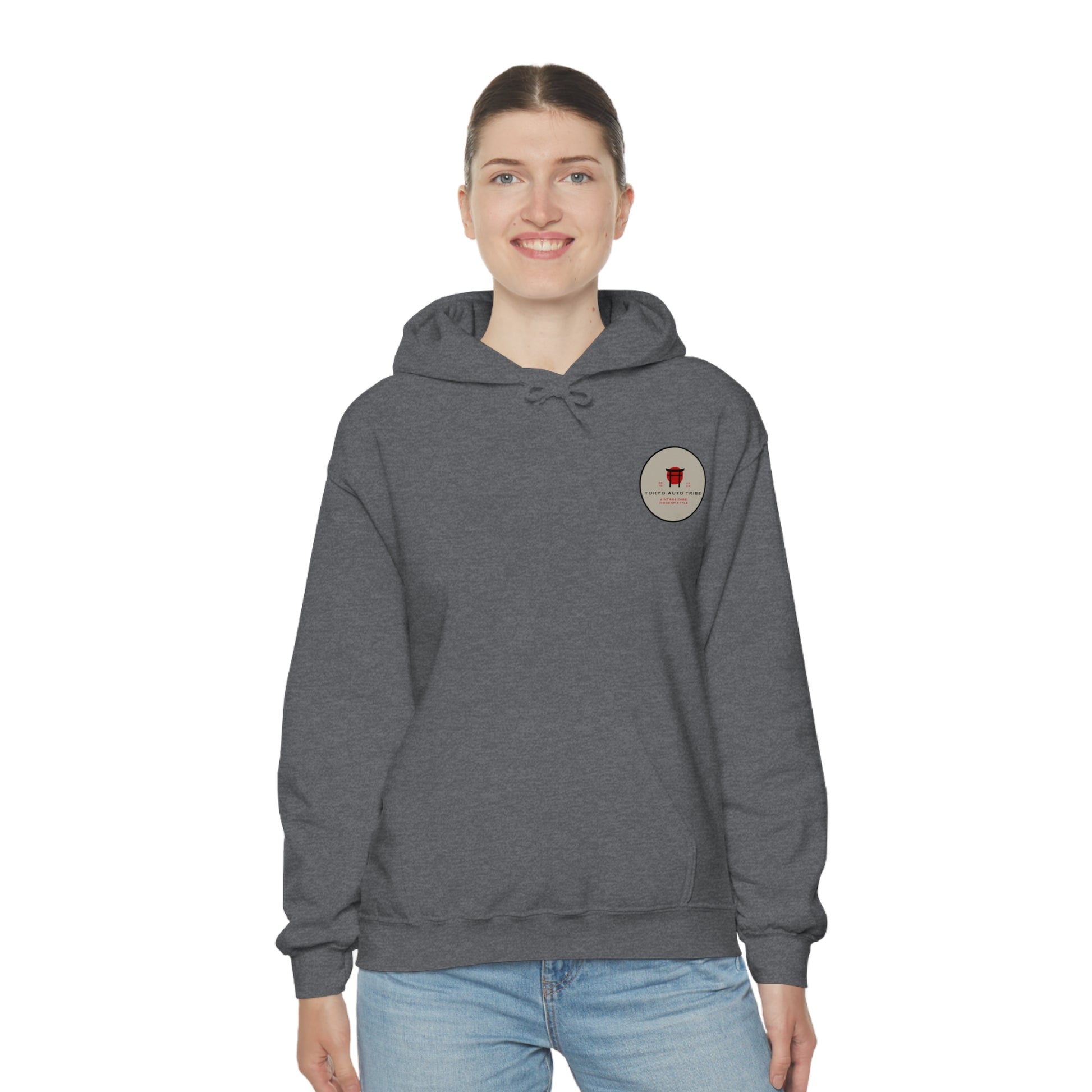 Woman wearing a dark grey Wagon Chibi Hoodie featuring a small circular graphic on the chest, embodying Japanese car culture and late-night drive vibes from Tokyo Auto Tribe.