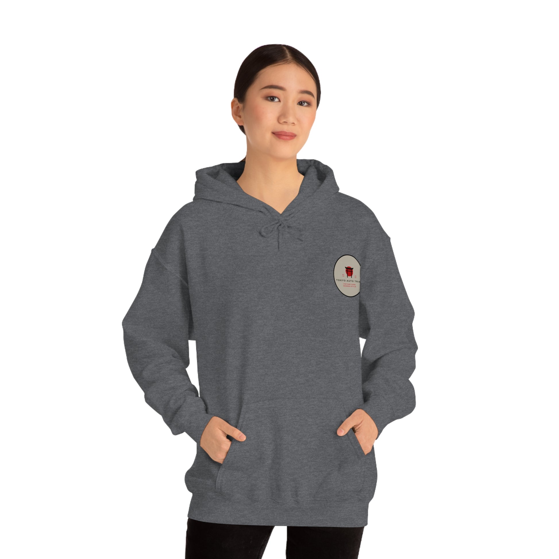 Woman wearing a dark gray Wagon Chibi Hoodie with a subtle Japanese car culture patch on the chest, styled for fans of JDM streetwear and tuner car culture.