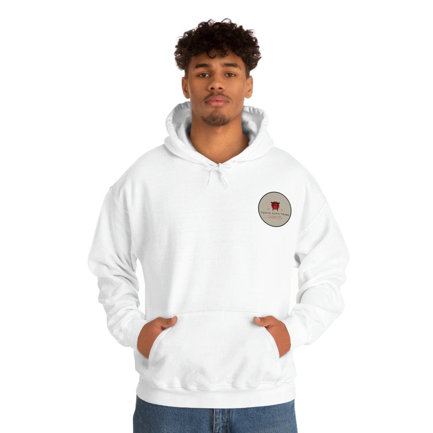 A young man wearing a white Groovy Grocery Runner Hoodie featuring a small graphic patch on the chest, embodying Japanese car culture and late-night tuner vibes.