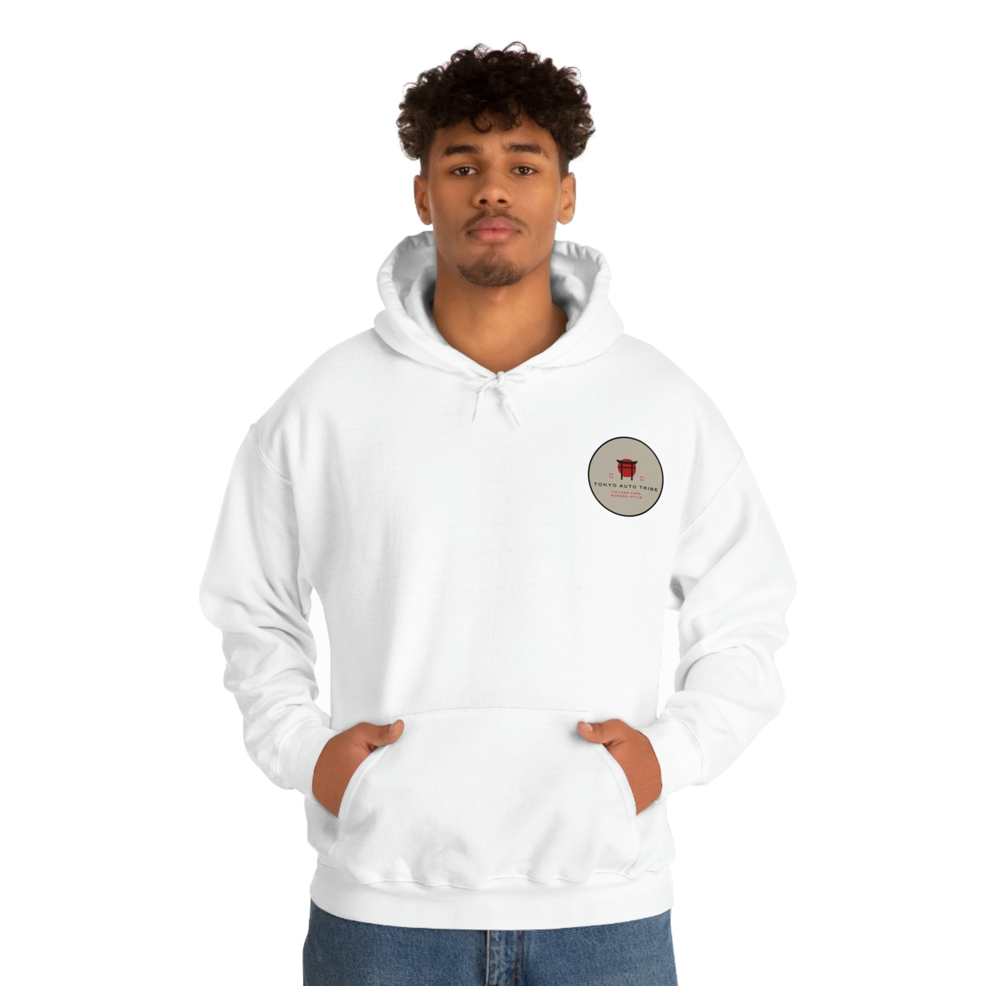 A young man wearing a white Groovy Grocery Runner Hoodie featuring a small graphic patch on the chest, embodying Japanese car culture and late-night tuner vibes.