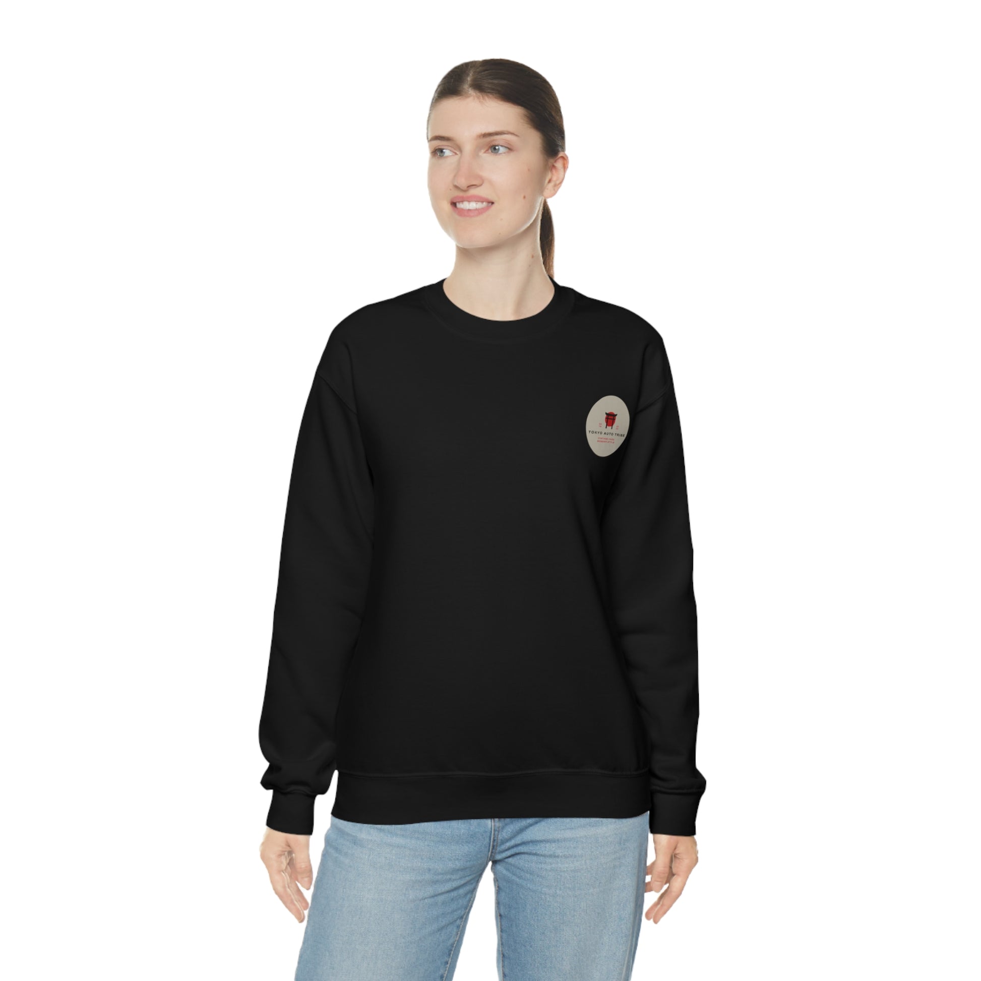 Woman wearing a black Wagon Chibi Sweater with a small vintage-style logo on the chest, paired with light blue jeans, embodying casual JDM streetwear inspired by Japanese car culture.