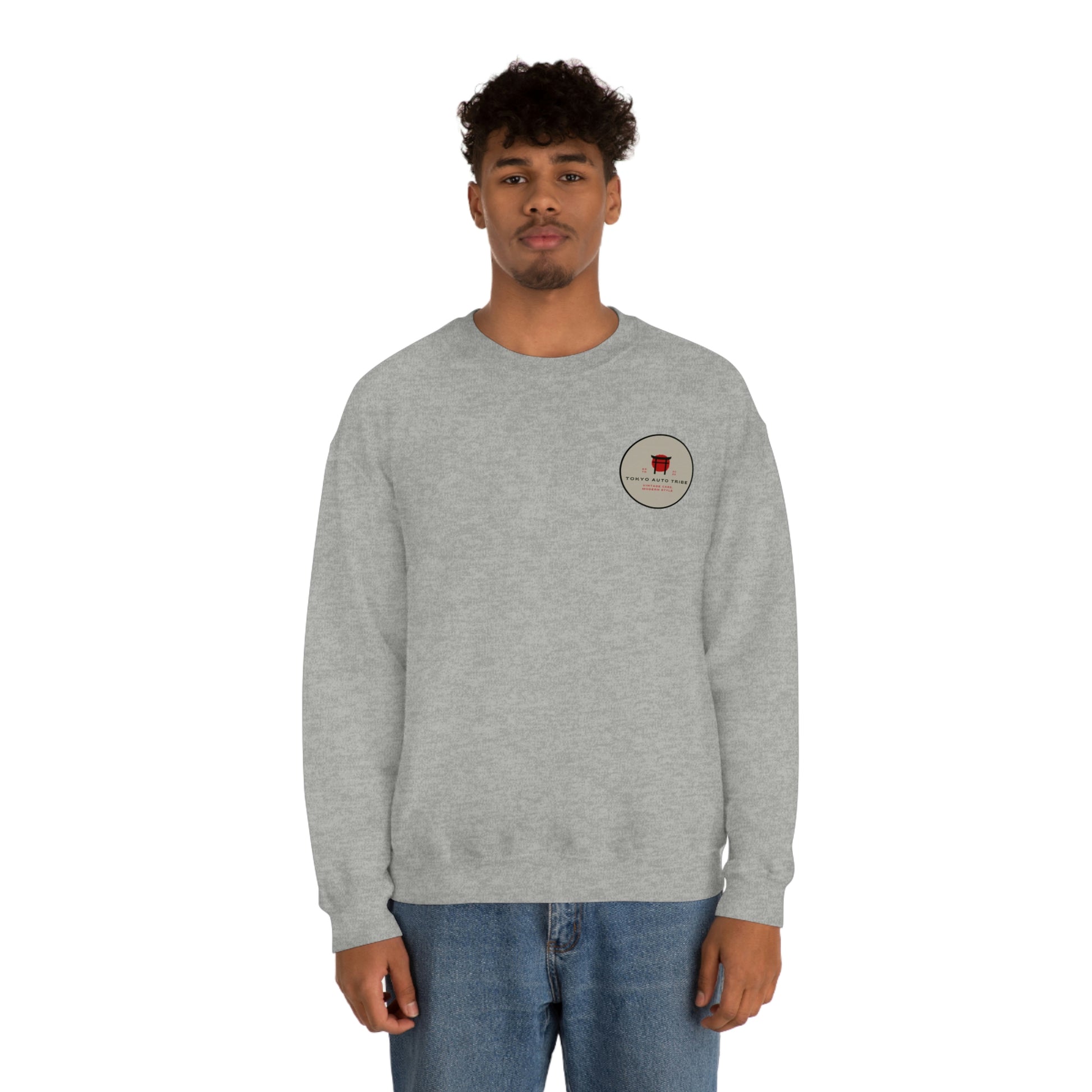 Front view of a man wearing The Family Wagon Sweater, a light gray crewneck sweatshirt with a small circular logo on the chest, perfect Japanese car culture streetwear for enthusiasts.