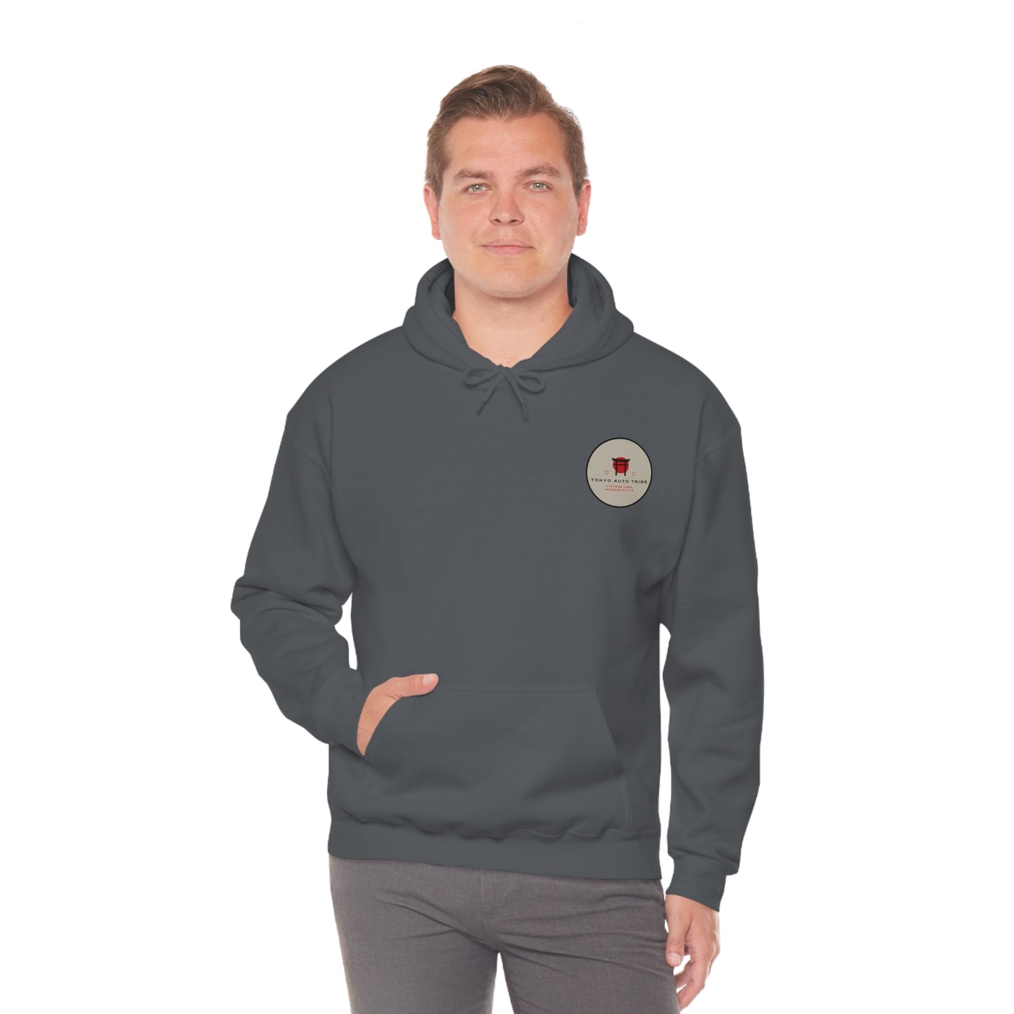 Man wearing a dark gray Wagon Chibi Hoodie featuring a small circular graphic on the chest, designed for fans of Japanese car culture and late-night drives.