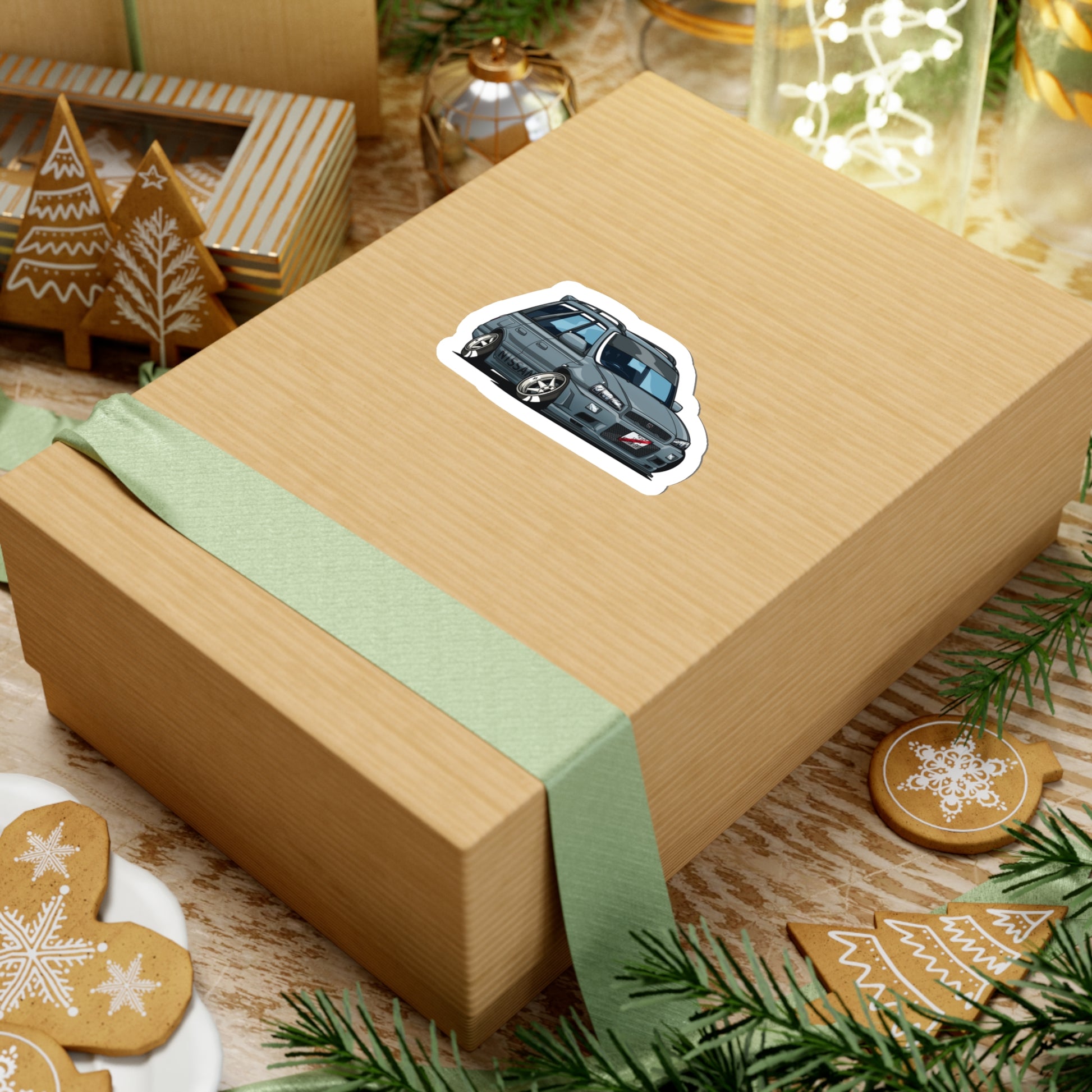 Wagon Wonder Sticker featuring a detailed illustration of a classic Japanese tuner car, placed on a rustic gift box surrounded by festive holiday decorations.