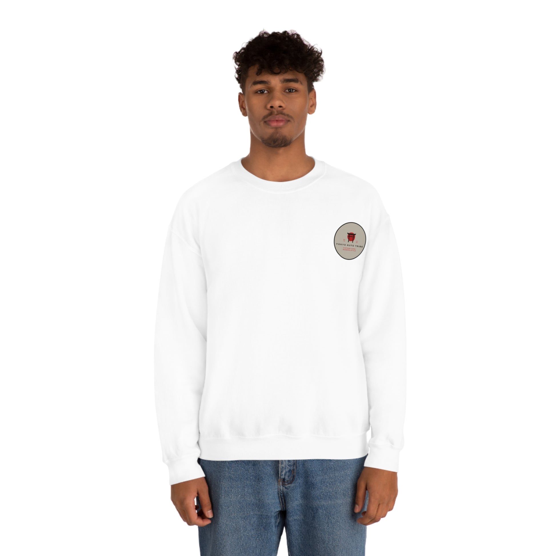 Man wearing a white Wagon Chibi Sweater with a small circular graphic on the chest, styled casually with blue jeans, reflecting Japanese car culture streetwear.
