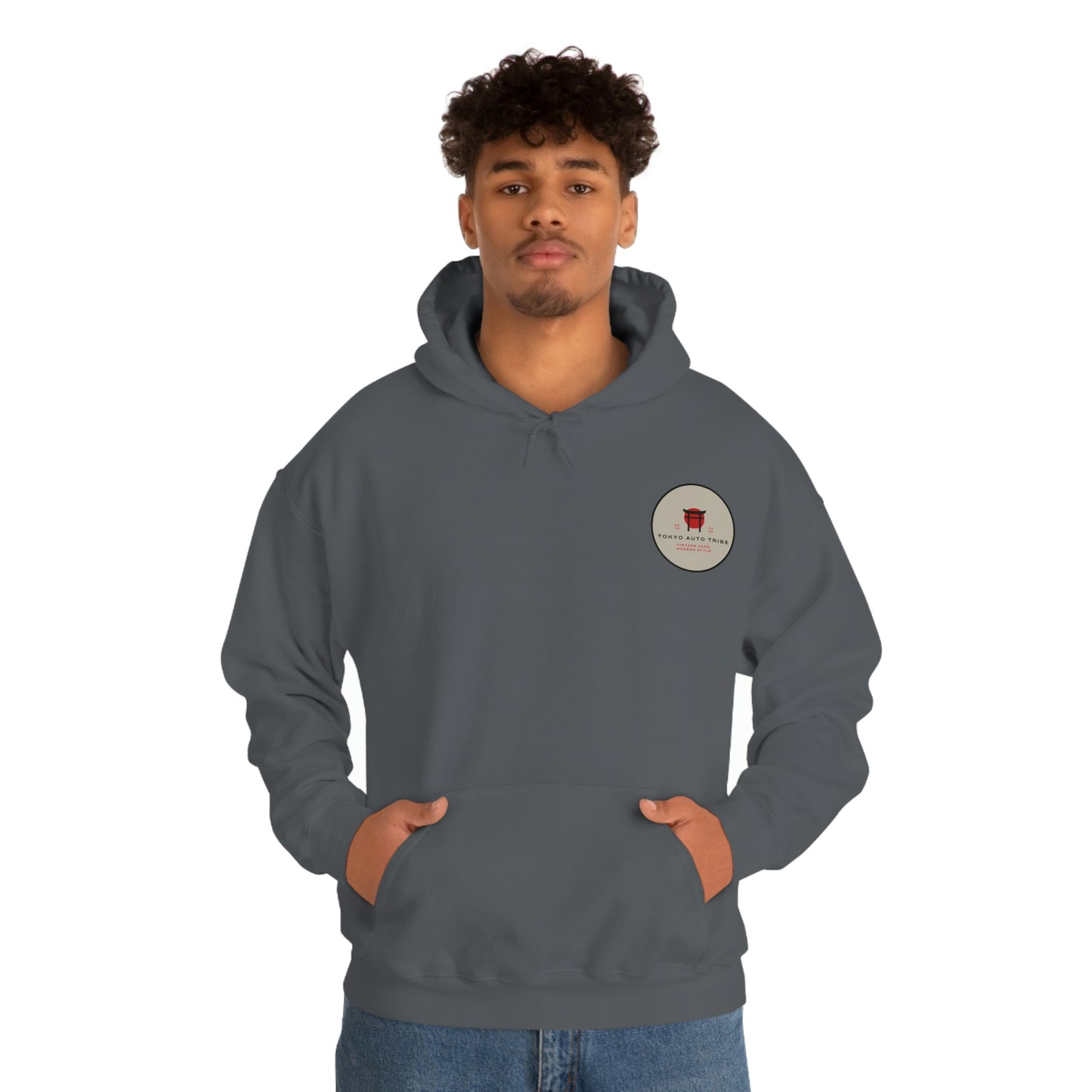Man wearing a dark gray Groovy Grocery Runner Hoodie with a small round graphic on the chest, embodying the spirit of Japanese car culture and late-night drives.