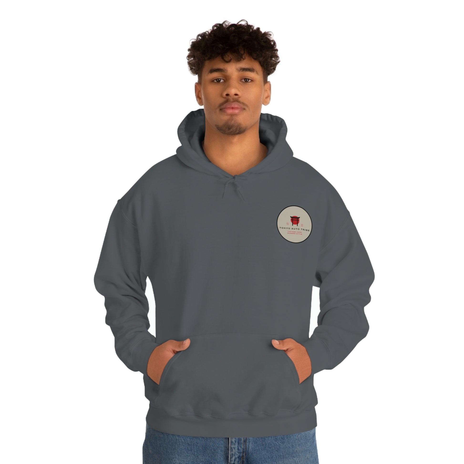 Man wearing a dark gray Groovy Grocery Runner Hoodie with a small round graphic on the chest, embodying the spirit of Japanese car culture and late-night drives.