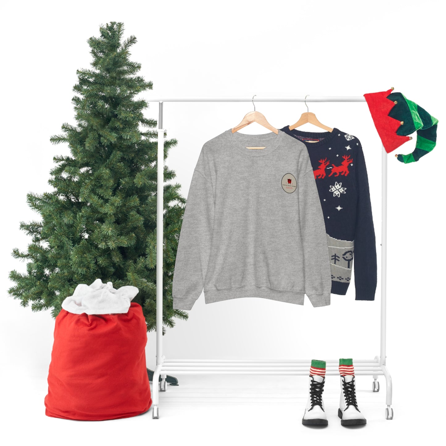 Gray Wagon Chibi Sweater hanging on a rack next to a festive Christmas tree, holiday-themed navy sweater, elf hats, and striped boots, evoking Japanese car culture nostalgia.