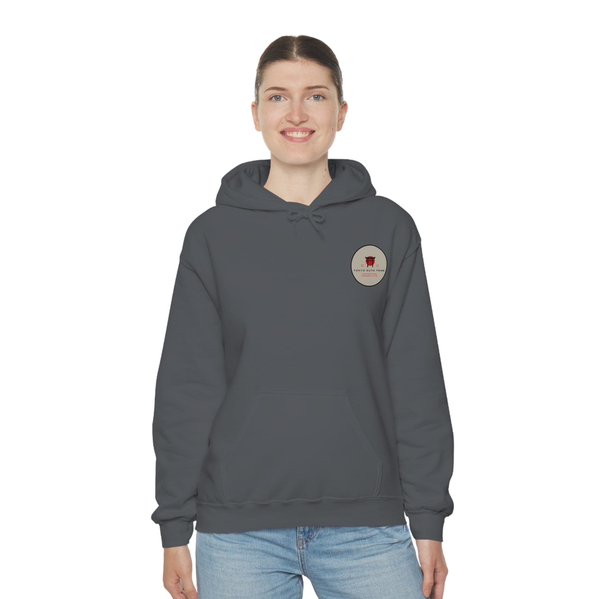 Smiling woman wearing a dark gray Wagon Chibi Hoodie with a small circular graphic on the chest, styled in casual streetwear inspired by Japanese car culture and late-night drives.