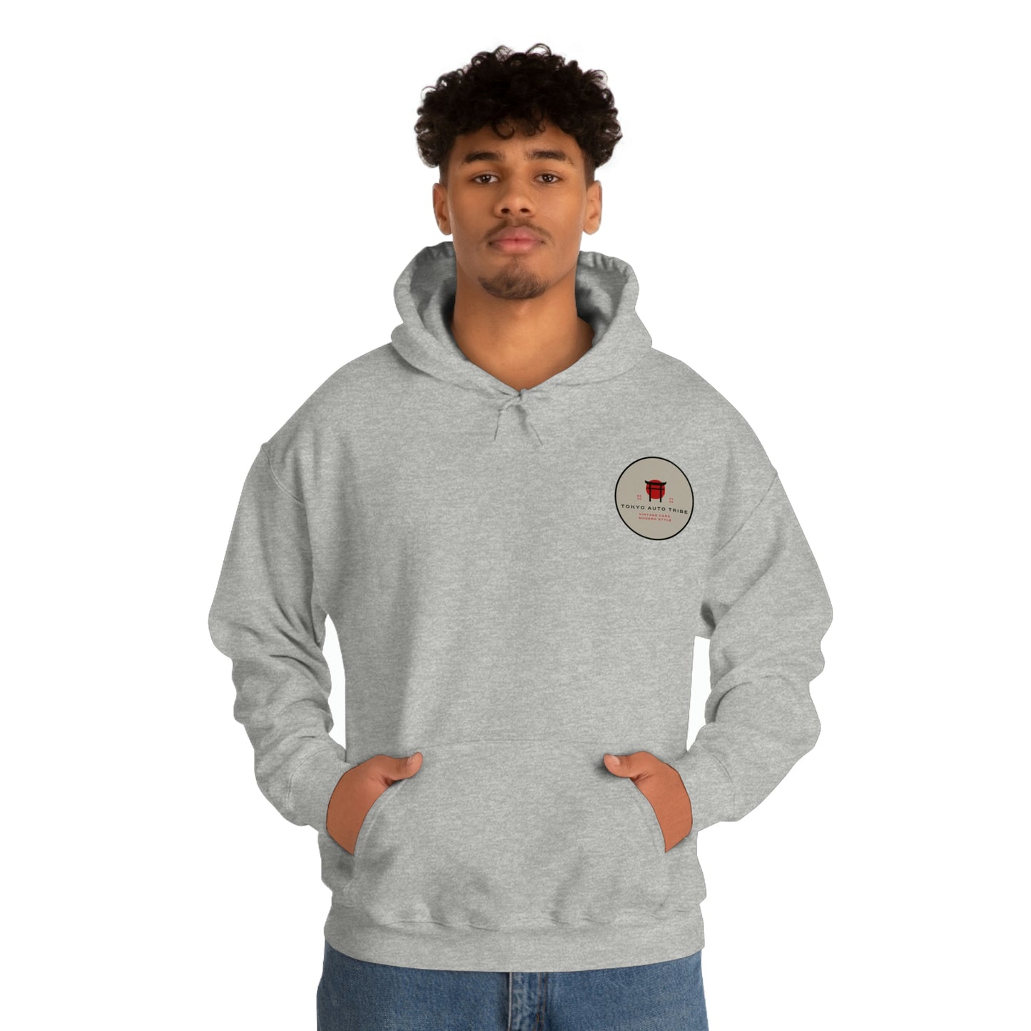 Man wearing a grey Groovy Grocery Runner Hoodie with a small red graphic logo on the chest, representing Japanese car culture and late-night driving lifestyle.