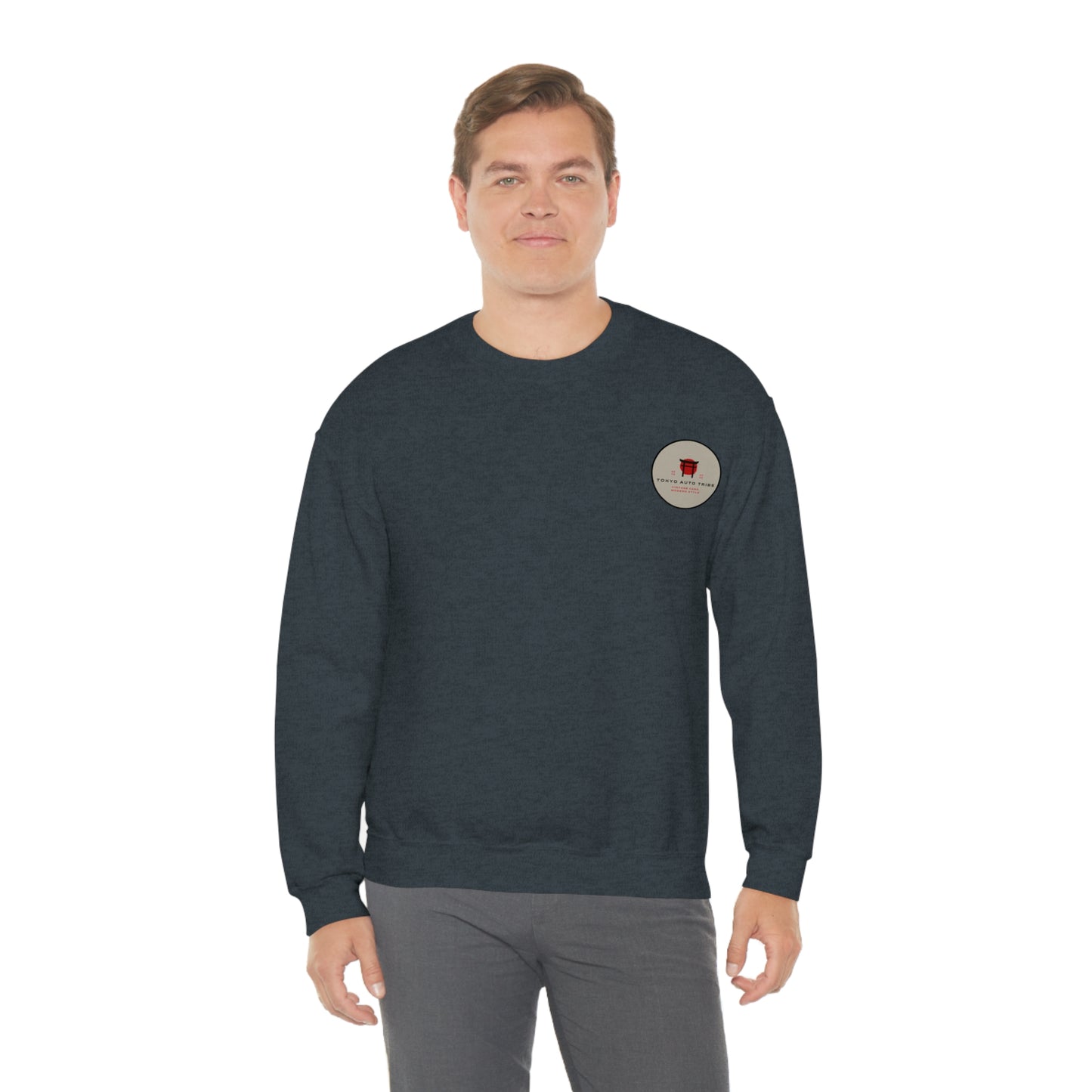 Man wearing a dark gray Wagon Chibi Sweater featuring a small round logo on the chest, styled for fans of Japanese car culture, late-night drives, and drift scenes.