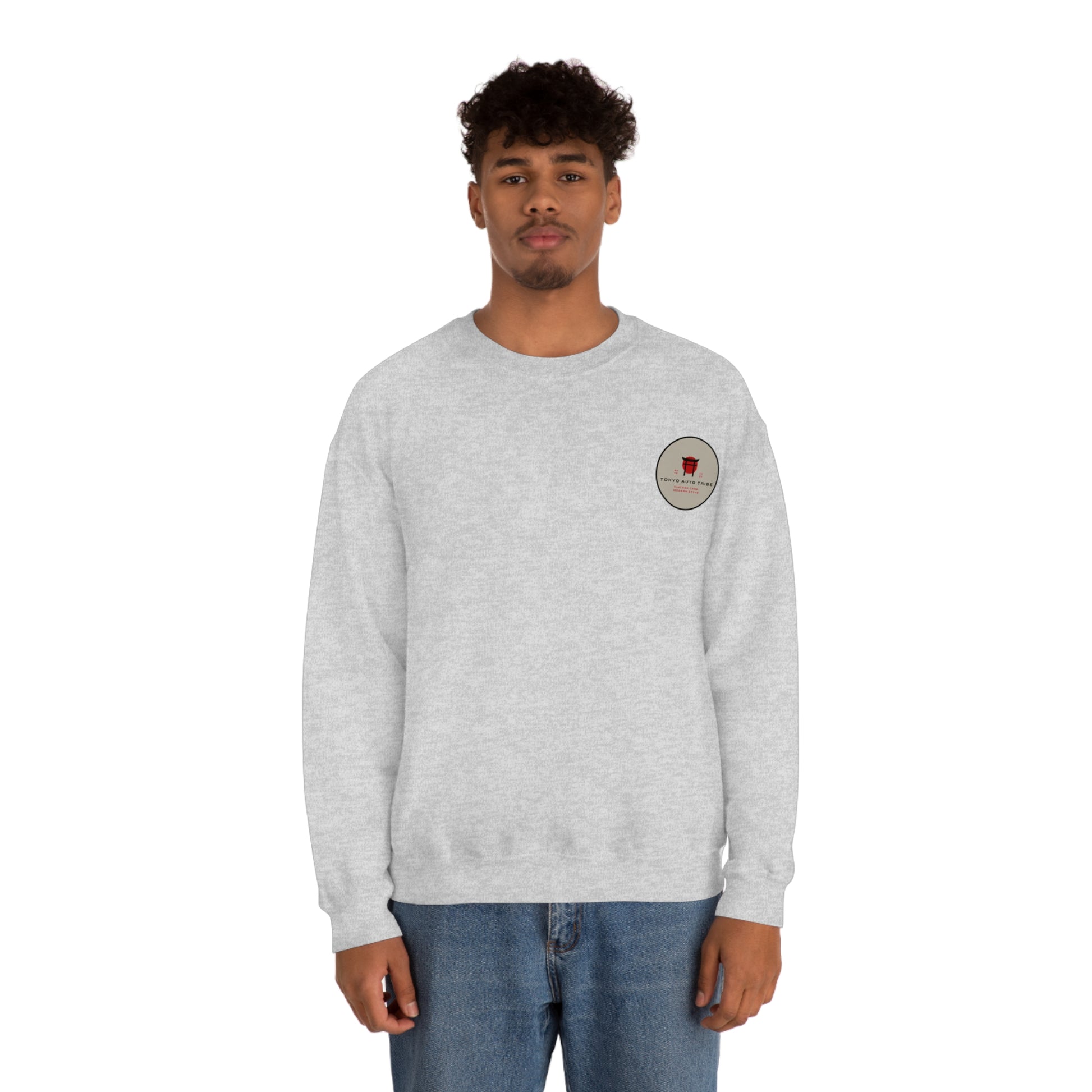 Man wearing a light gray Wagon Chibi Sweater featuring a small circular graphic on the chest, embodying the spirit of Japanese car culture and late-night drives.