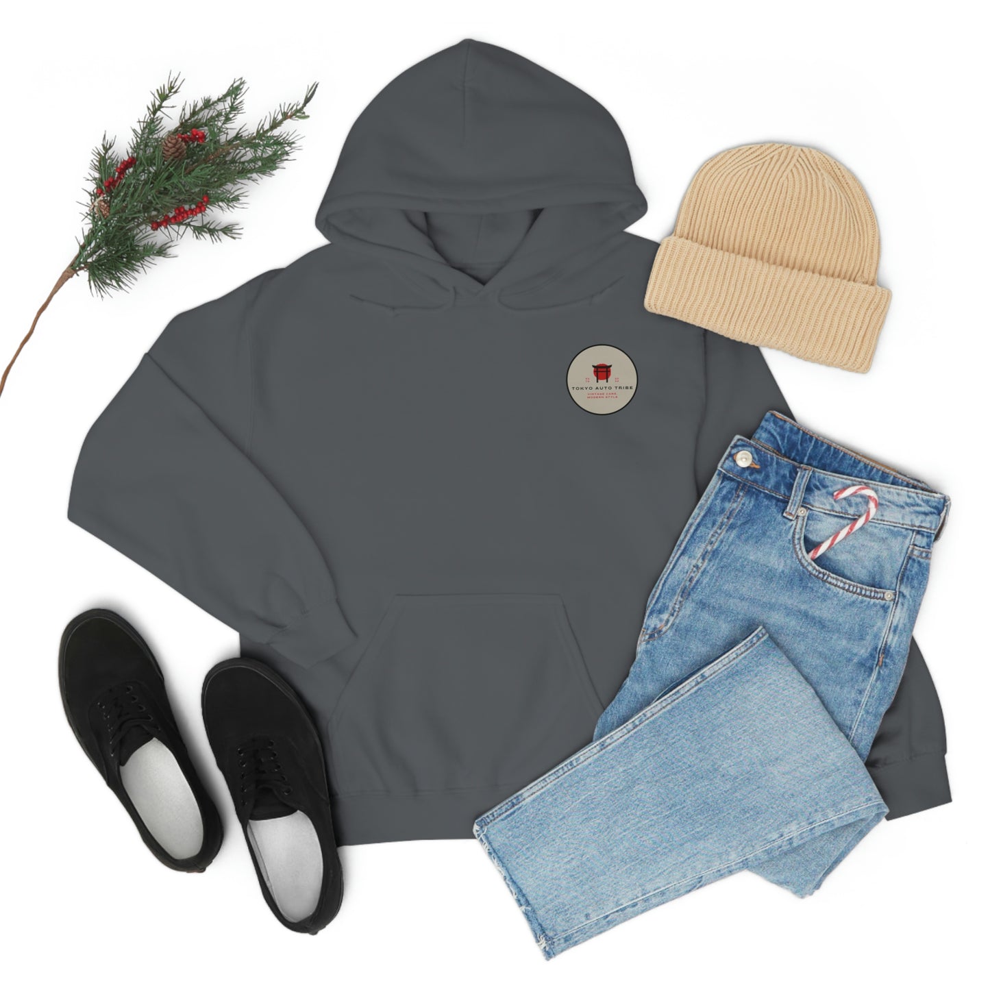 Flat lay of a dark gray Groovy Grocery Runner Hoodie paired with light blue jeans, black shoes, and a beige knit beanie, styled with a small pine branch and red berries for a cozy, casual look.
