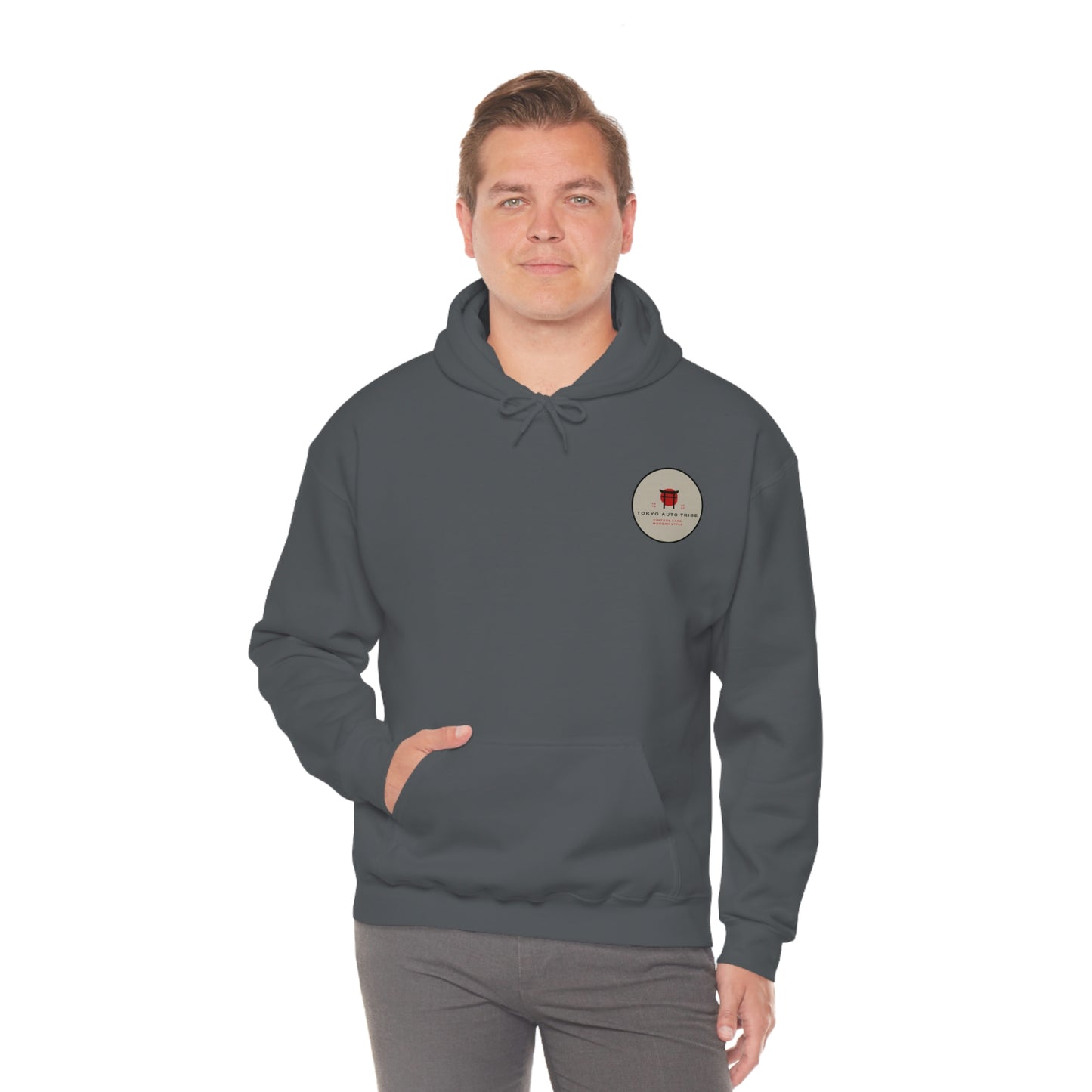 Man wearing a dark hoodie featuring a small logo patch on the chest, showcasing the Groovy Grocery Runner Hoodie designed for fans of Japanese car culture, drift, and tuner lifestyle.