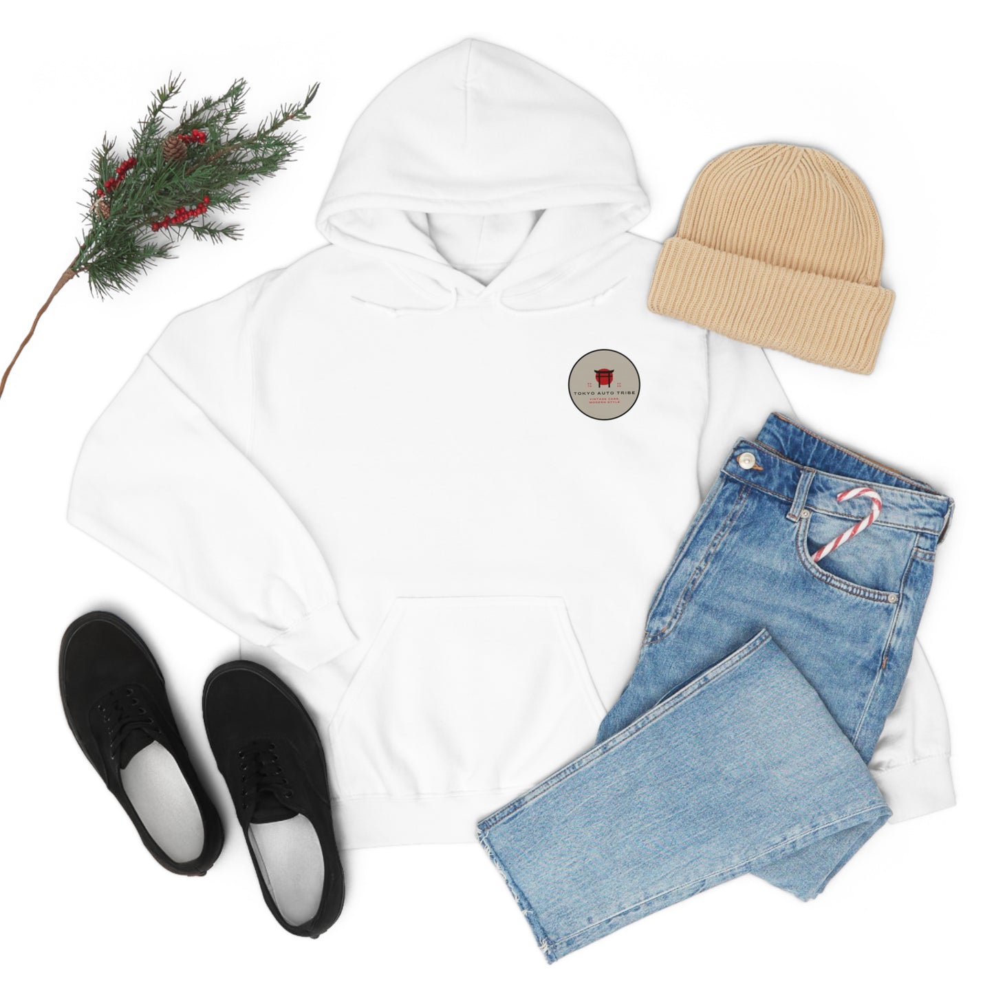 White Wagon Chibi Hoodie laid flat with light blue jeans featuring a candy cane in the pocket, black sneakers, beige knit beanie, and a small branch with red berries, showcasing casual JDM streetwear style for car enthusiasts.
