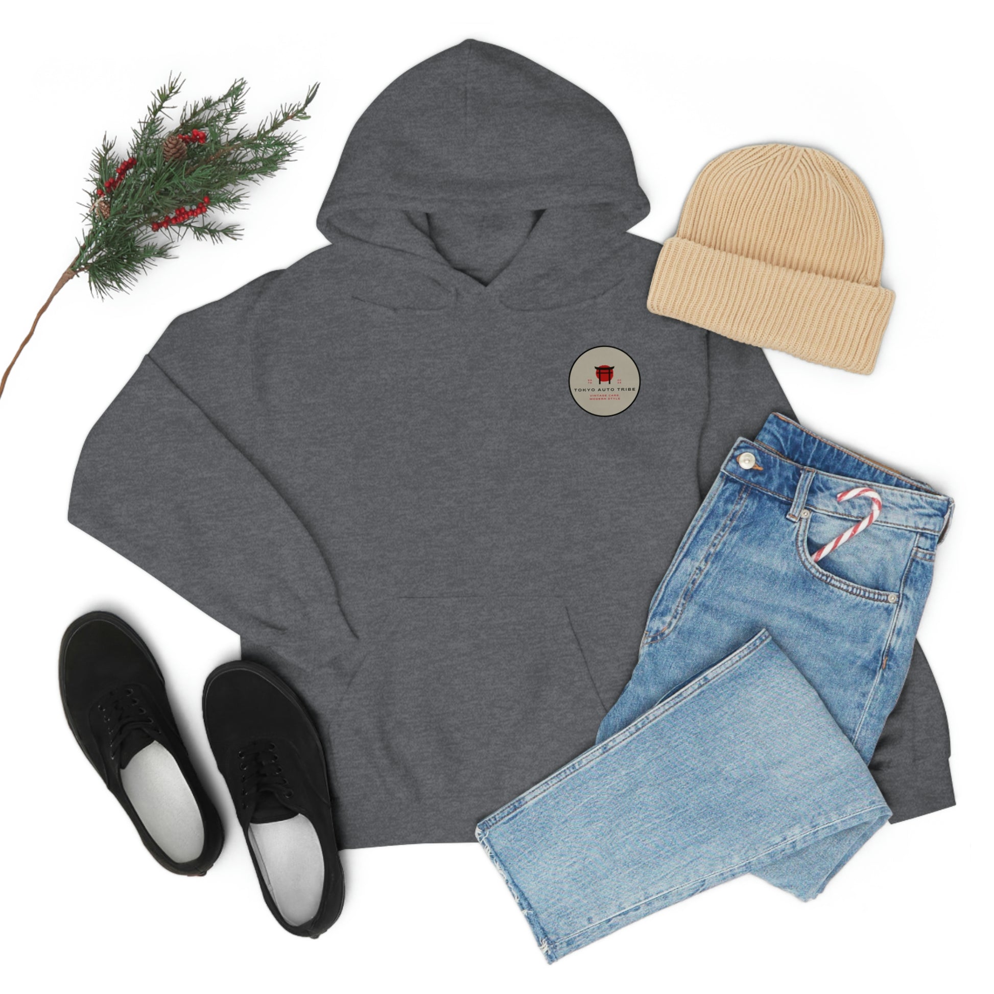 Dark gray Groovy Grocery Runner Hoodie laid flat with light blue jeans, black slip-on shoes, beige beanie, and festive pine branch, embodying Japanese car culture style.