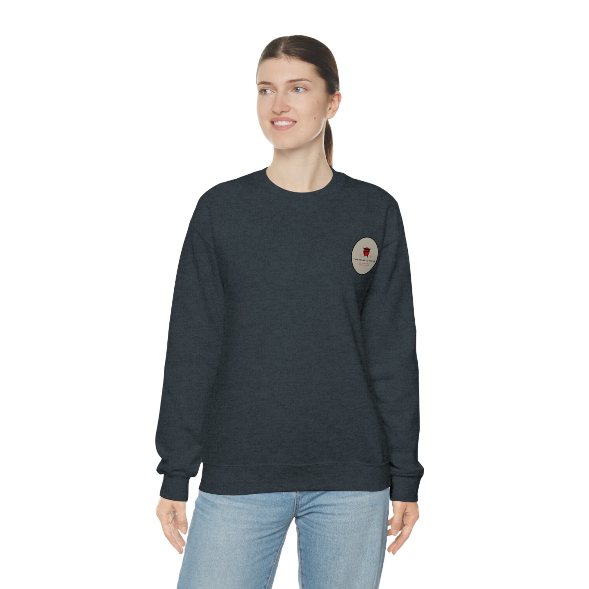 Woman wearing a dark gray Wagon Chibi Sweater with a small graphic on the chest, styled casually with light blue jeans, embodying vintage Japanese car culture atmosphere.
