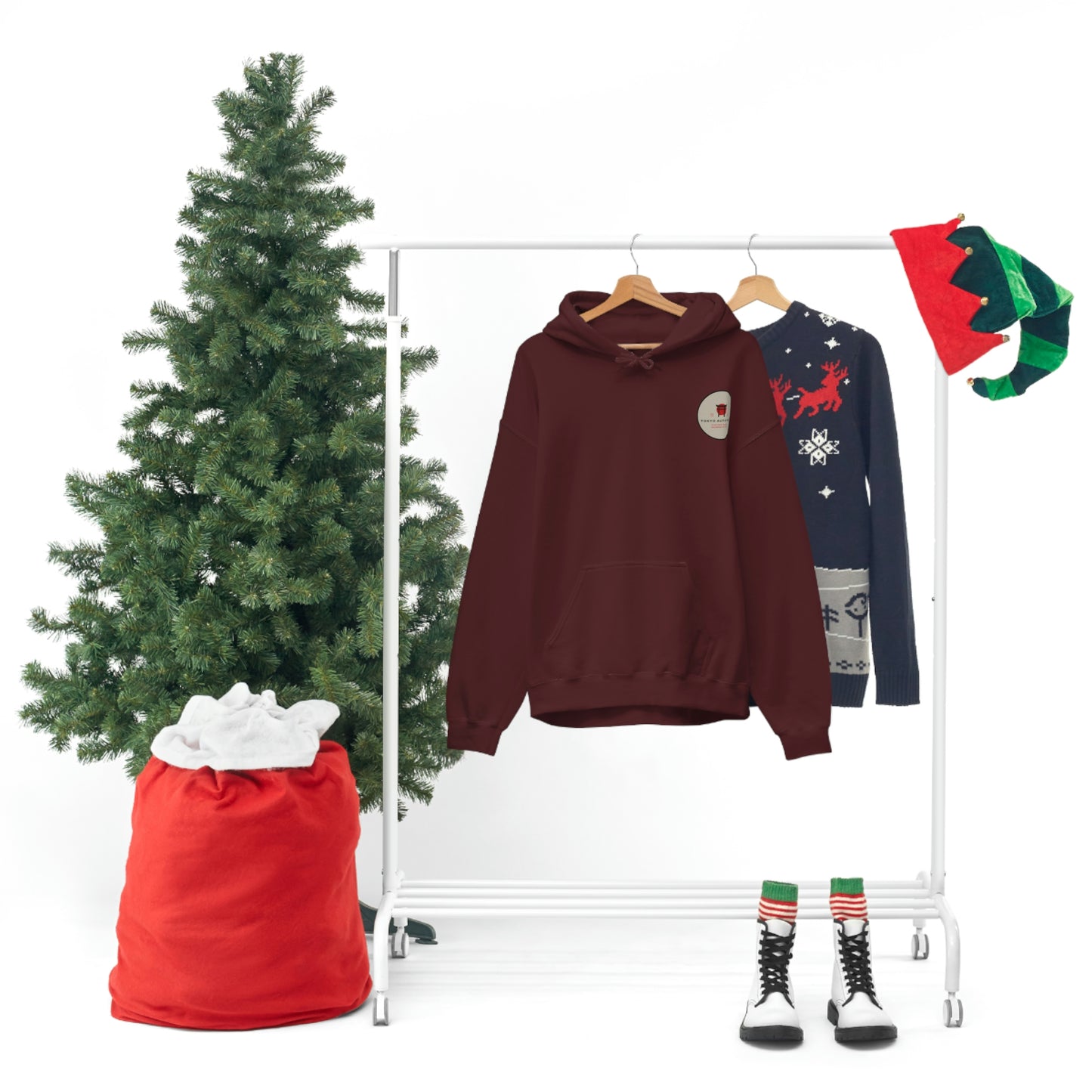 Groovy Grocery Runner Hoodie in deep maroon hanging on a rack next to a festive sweater, with a decorated Christmas tree, red sack, elf hats, and striped boots creating a holiday-themed display.