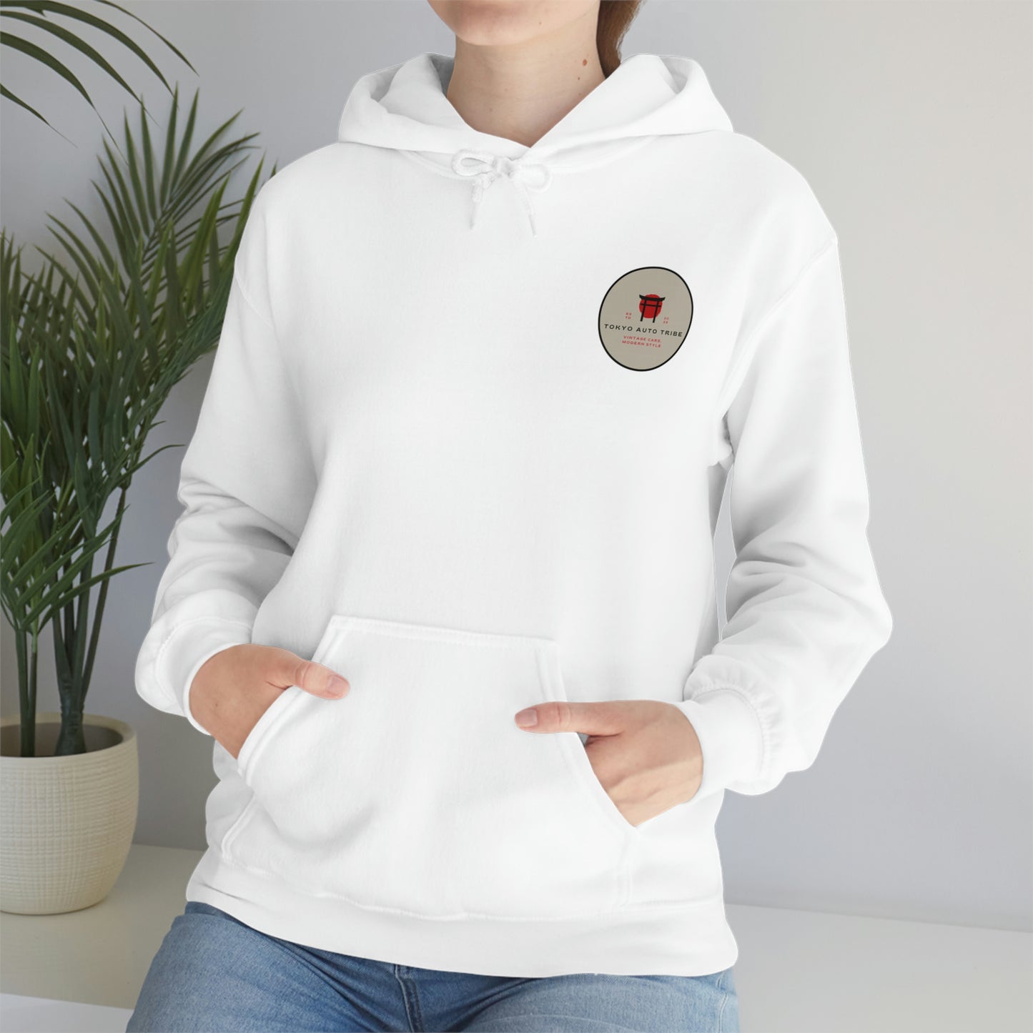 Person wearing a white Groovy Grocery Runner Hoodie with a small vintage-style Tokyo Auto Tribe logo on the chest, styled for fans of Japanese car culture and late-night drives.