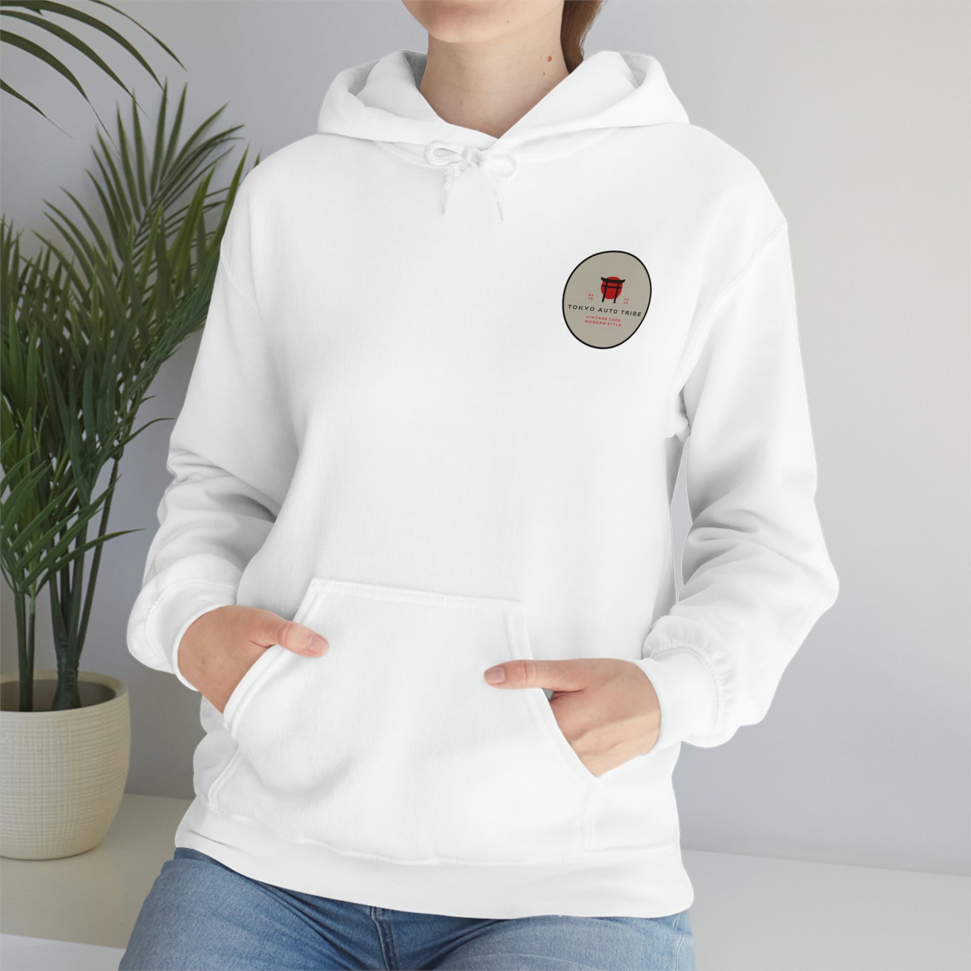 Person wearing a white Groovy Grocery Runner Hoodie with a small vintage-style Tokyo Auto Tribe logo on the chest, styled for fans of Japanese car culture and late-night drives.