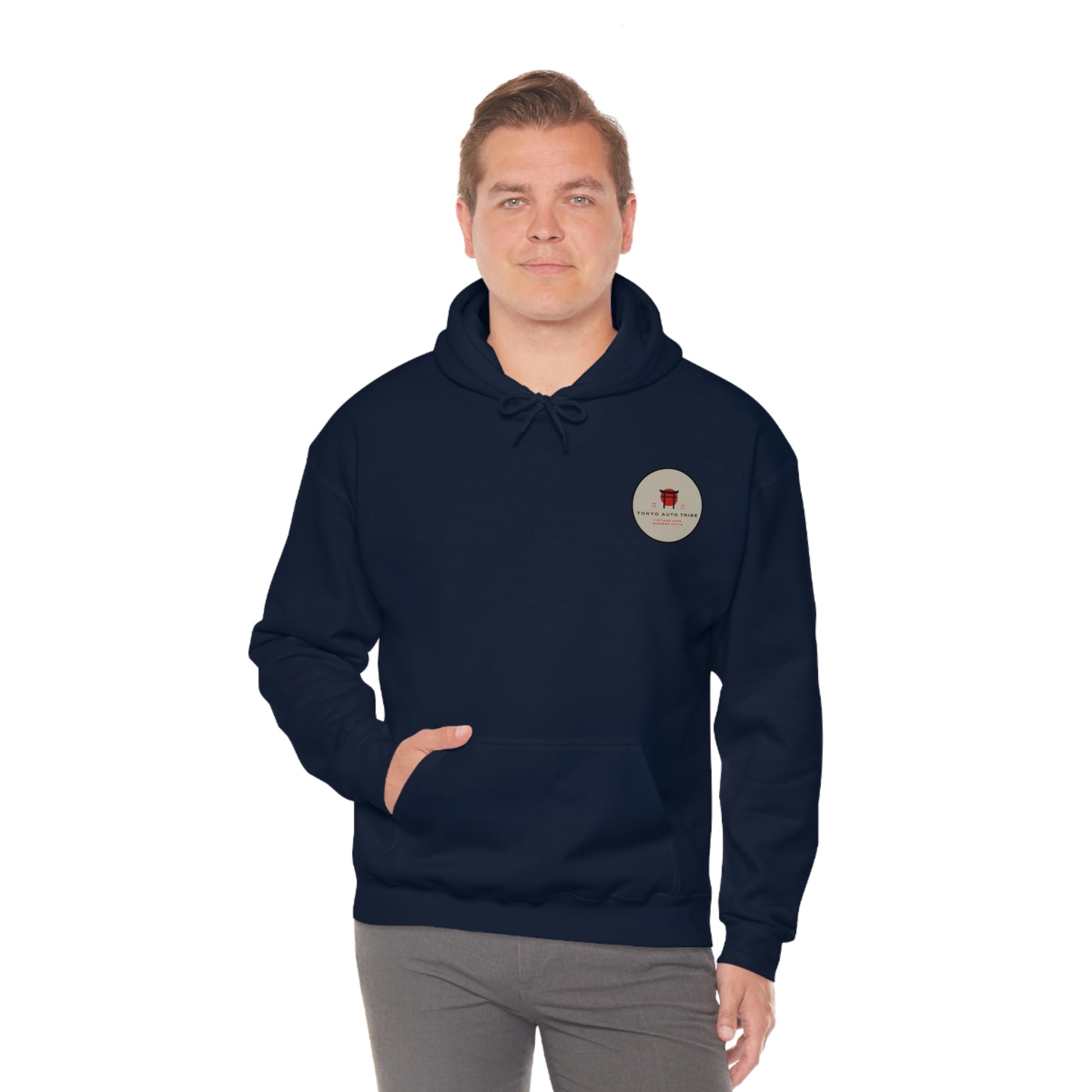 Man wearing a navy blue Groovy Grocery Runner Hoodie with a small vintage-inspired circular graphic on the chest, embodying Japanese car culture and late-night drives.
