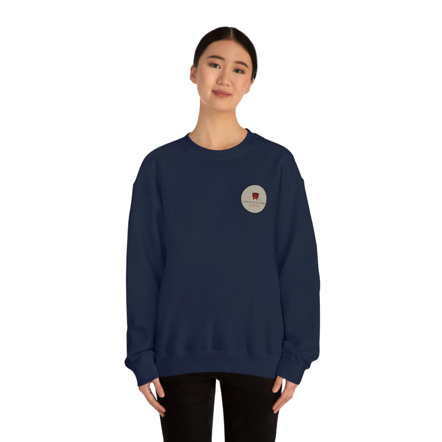 A woman wearing a navy blue sweatshirt with a small circular graphic on the chest, featuring a minimalist design, representing The Family Wagon Sweater inspired by Japanese car culture and late-night drives.