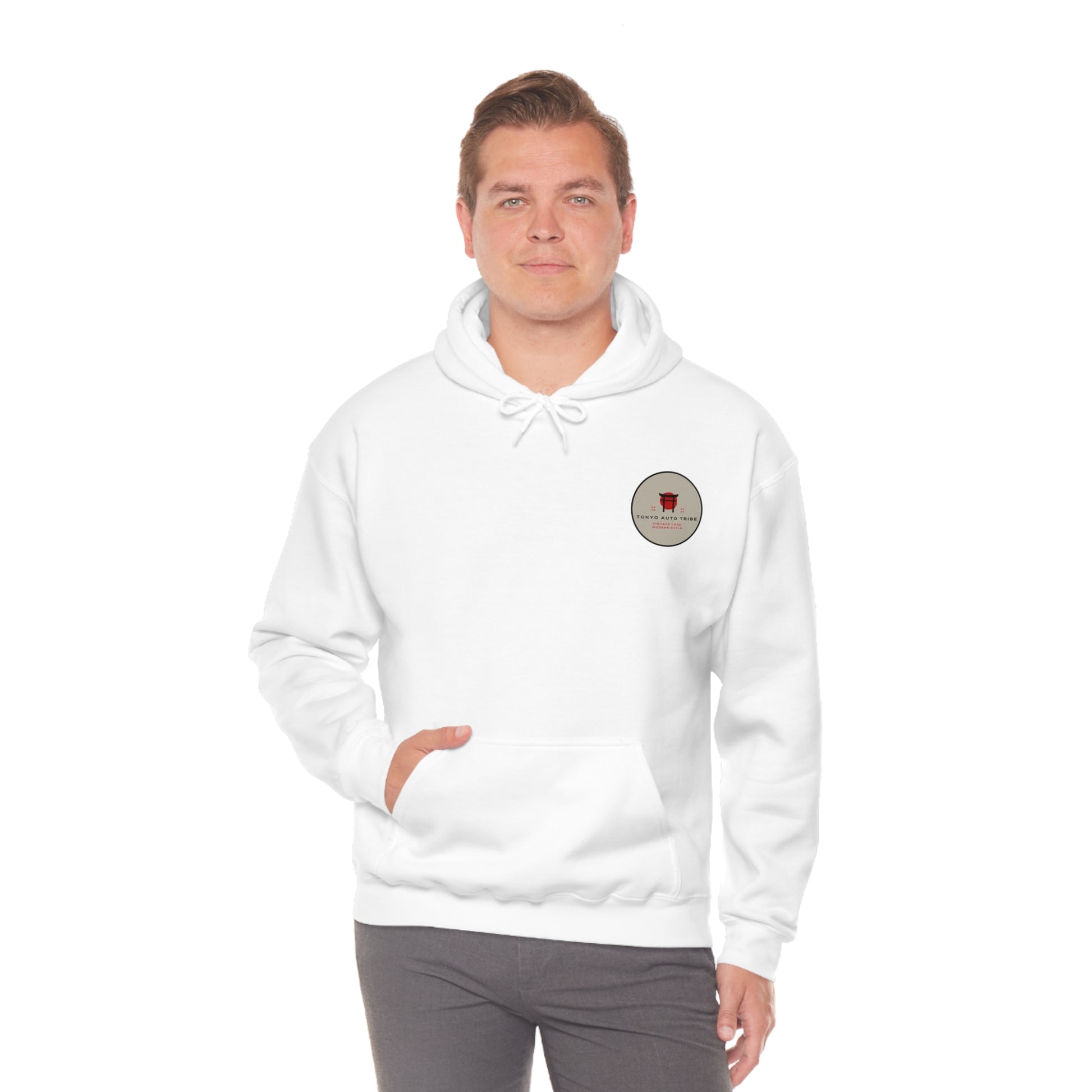Man wearing a white Wagon Chibi Hoodie featuring a small round patch graphic on the chest, reflecting Japanese car culture and streetwear style inspired by late-night drives and tuner scenes.