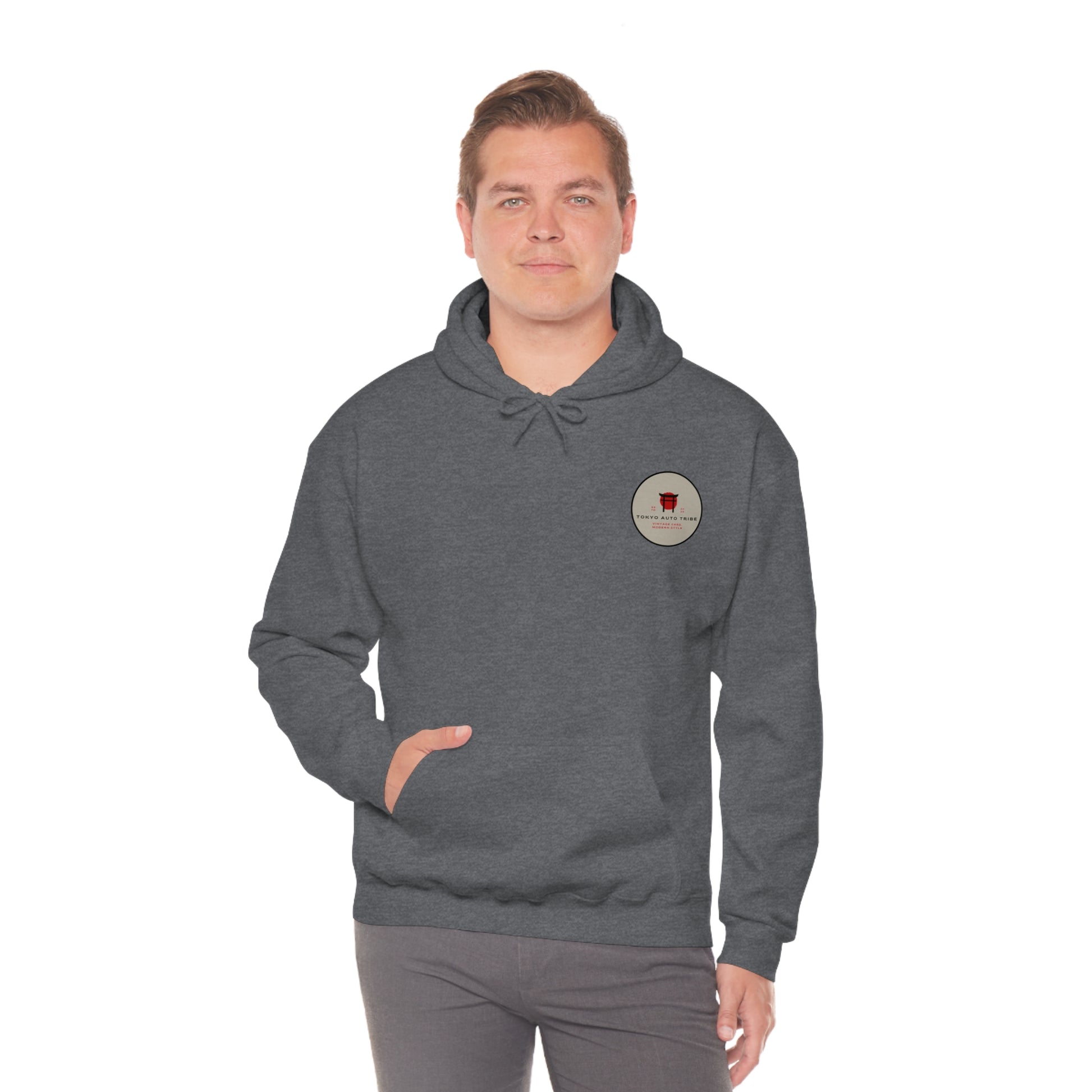 Man wearing a dark gray Wagon Chibi Hoodie with a small circular logo on the chest, blending JDM streetwear style with vintage Japanese car culture vibes.