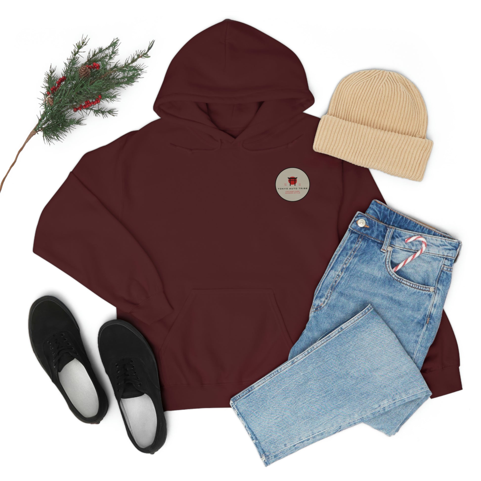 Maroon Groovy Grocery Runner Hoodie styled with light blue jeans, black slip-on shoes, beige knit beanie, and festive pine branch, embodying casual automotive streetwear.