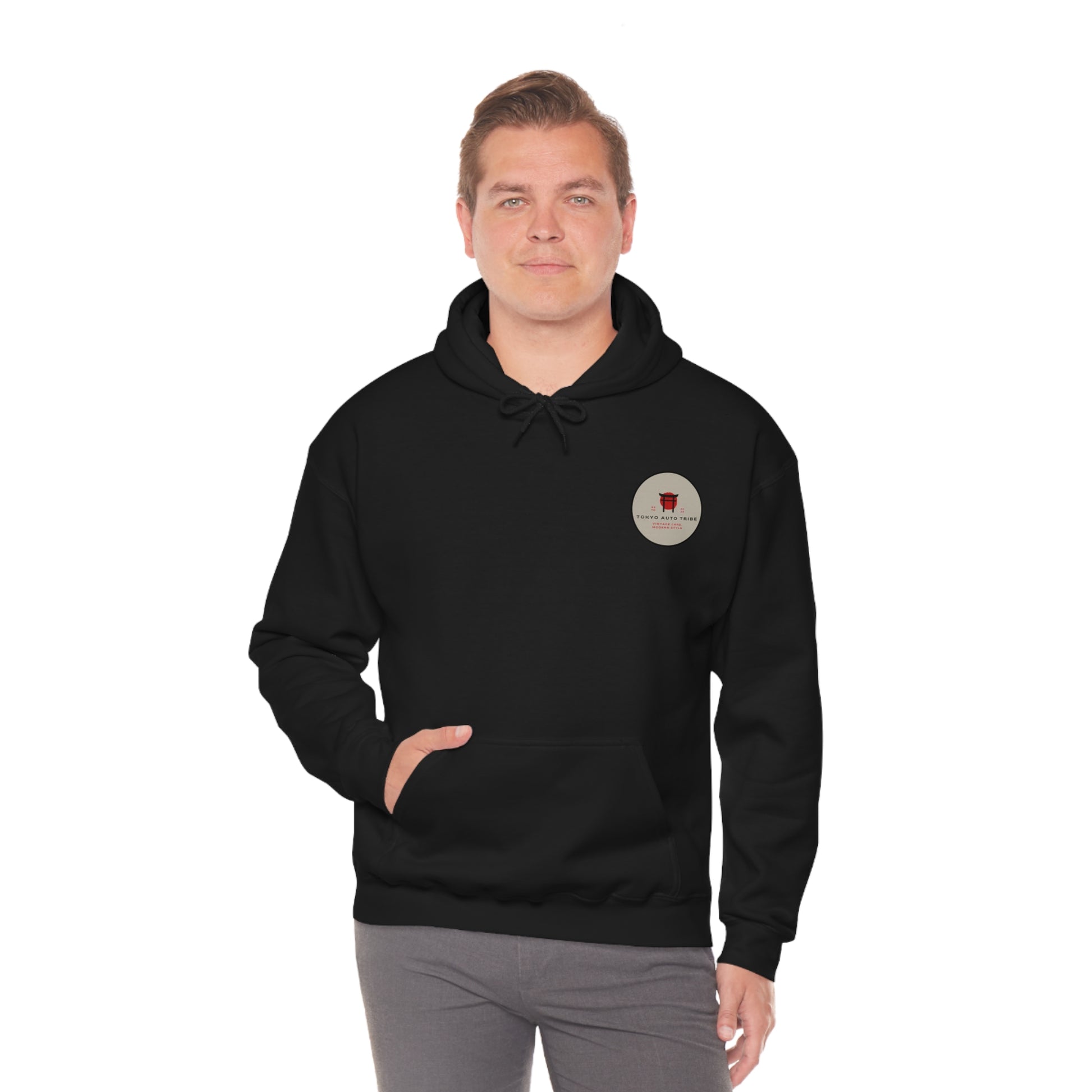 Man wearing a black Wagon Chibi Hoodie with a small circular graphic on the chest, embodying JDM streetwear culture for fans of late-night drives and Japanese tuner style.