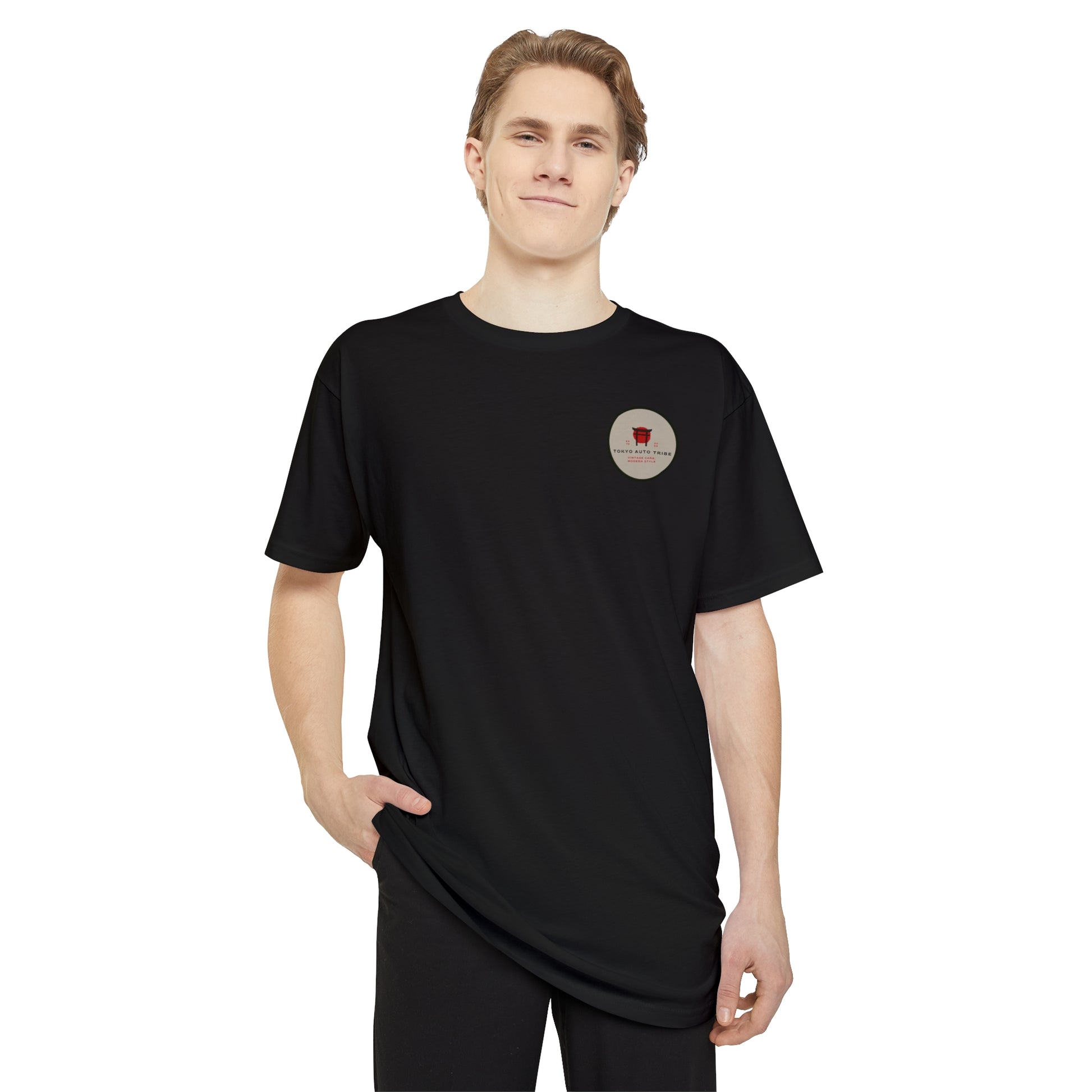 Young man wearing a black Unbreakable Spirit oversized T-Shirt with a small circular graphic on the chest, embodying the Tokyo Auto Tribe vibe of late-night Japanese car culture and tuner spirit.