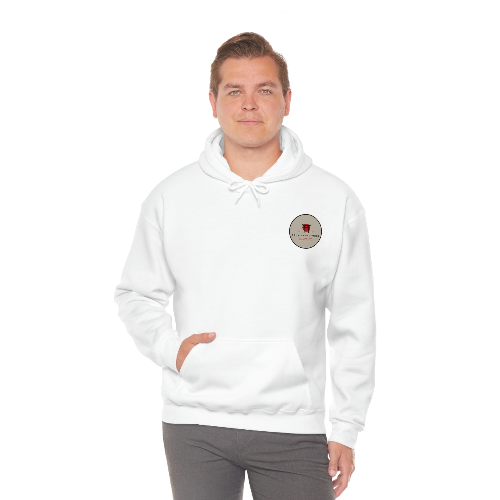 Man wearing a white Groovy Grocery Runner Hoodie with front pocket and small circular Japanese car culture graphic on the chest, styled for automotive streetwear fans.