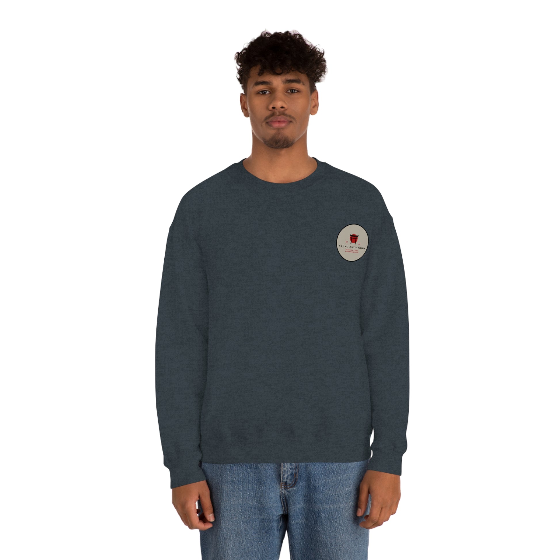Man wearing a dark gray Wagon Chibi Sweater with a small round graphic on the chest, styled with casual blue jeans, embodying Japanese car culture and late-night drive vibes.