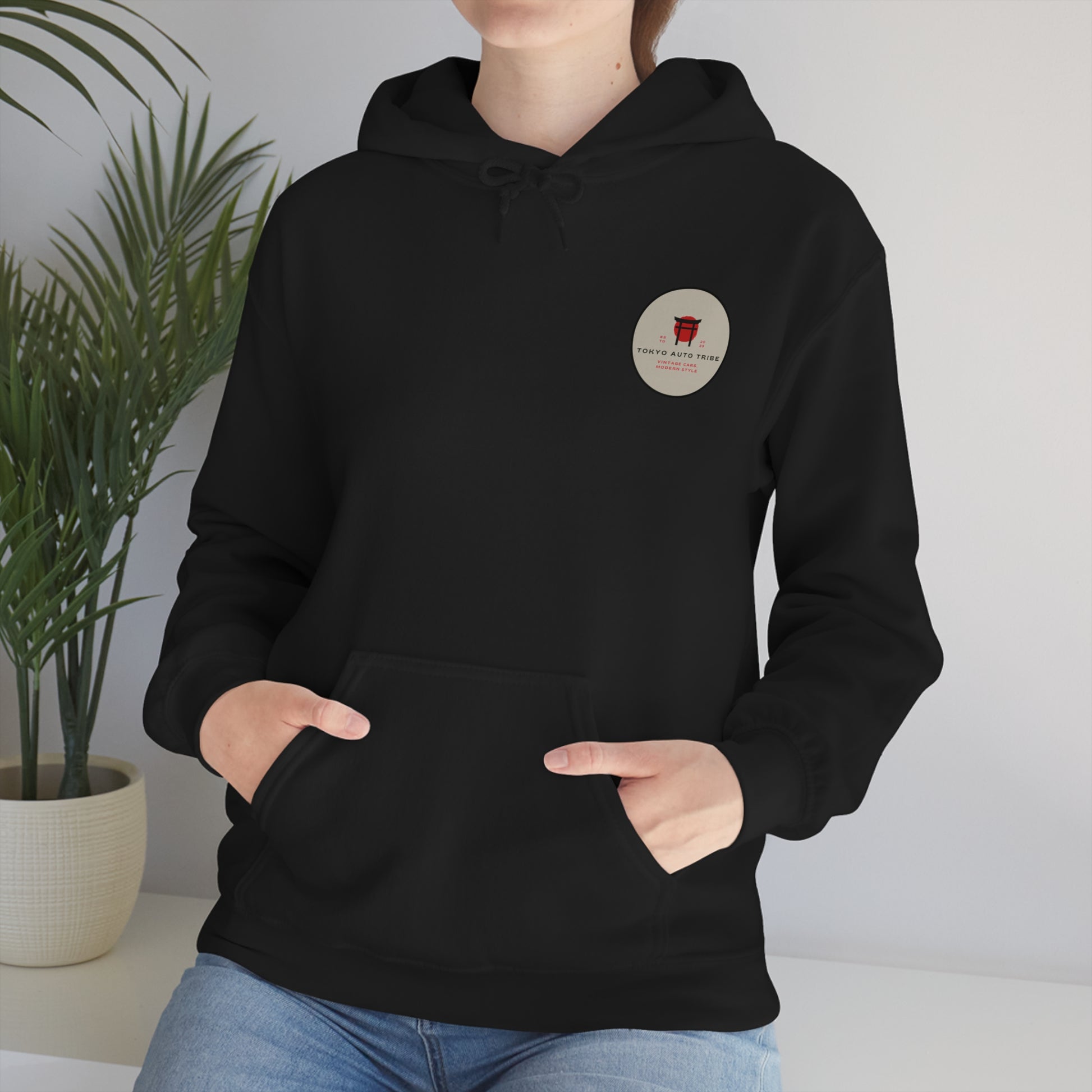 Person wearing a black Wagon Chibi Hoodie featuring a small red graphic and text on the chest, styled for fans of Japanese car culture and late-night drift scenes.