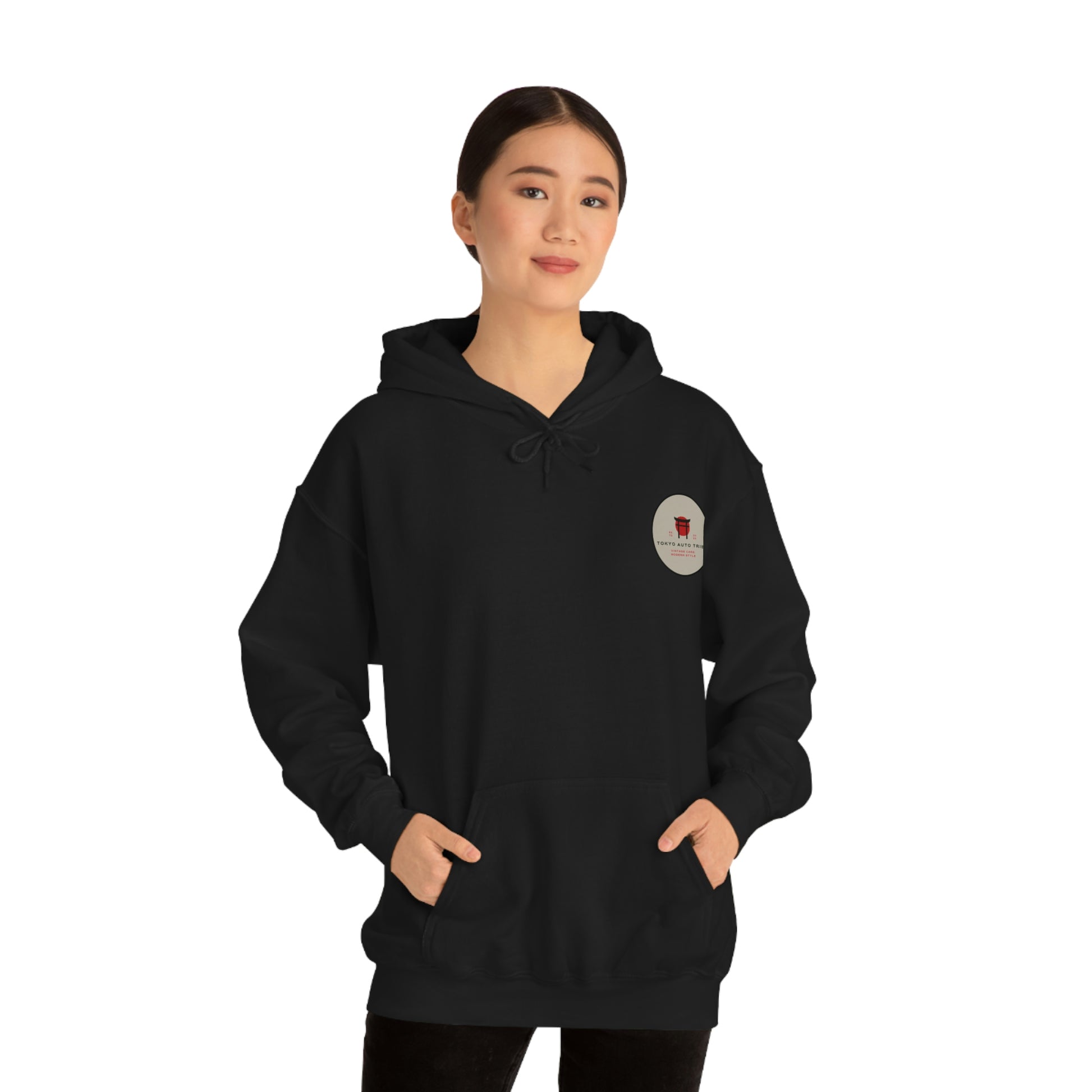 Young woman wearing a black Groovy Grocery Runner Hoodie with a small circular graphic on the chest, embodying the spirit of Japanese car culture and late-night drives.